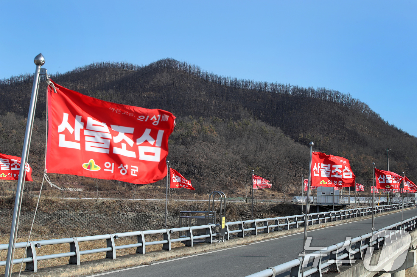 (의성=뉴스1) 공정식 기자 = 차고 건조한 날씨가 이어진 29일 경북 의성군 단촌면의 한 야산 앞에 산불조심 깃발이 바람에 나부끼고 있다. 뒤로 시커멓게 그을린 산은 지난해 경북 …