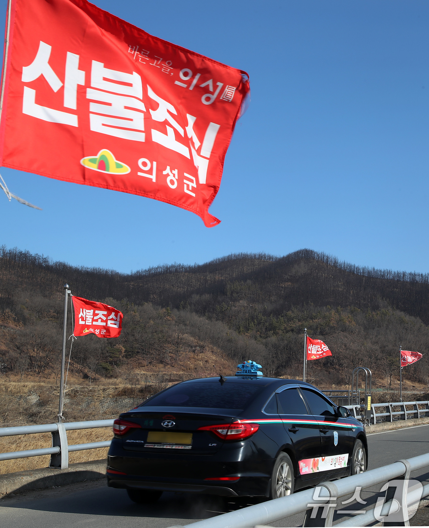 (의성=뉴스1) 공정식 기자 = 차고 건조한 날씨가 이어진 29일 경북 의성군 단촌면의 한 야산 앞에 산불조심 깃발이 바람에 나부끼고 있다. 뒤로 시커멓게 그을린 산은 지난해 경북 …