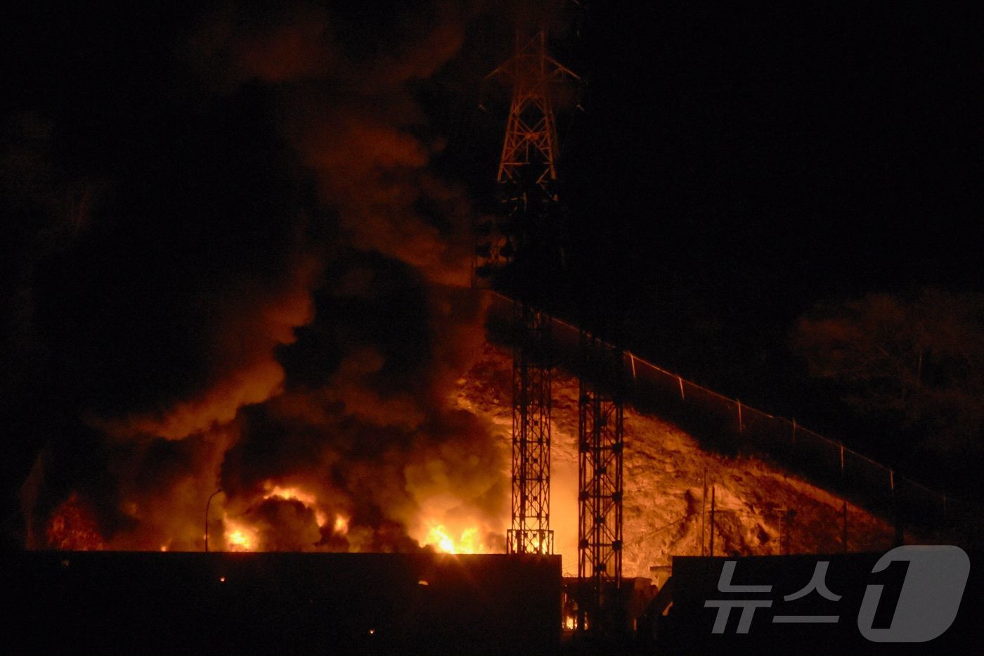 (AFP=뉴스1) = 3일(현지시간) 베네수엘라 수도 카라카스에서 연쇄 폭발이 발생한 이후 베네수엘라 최대의 군사 시설인 푸에르테 티우나에서 불길이 치솟고 있다. 2025.1.3ⓒ …