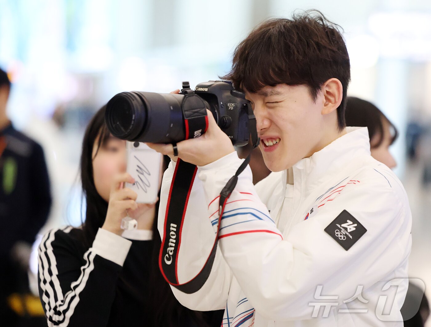 본문 이미지 - 2026 밀라노·코르티나담페초 동계올림픽에 출전하는 대한민국 쇼트트랙 대표팀의 임종언이 30일 오전 인천국제공항 제2터미널을 통해 이탈리아 밀라노로 출국 전 응원 온 팬의 카메라로 사진을 찍고 있다. 2026.1.30/뉴스1 ⓒ News1 김진환 기자