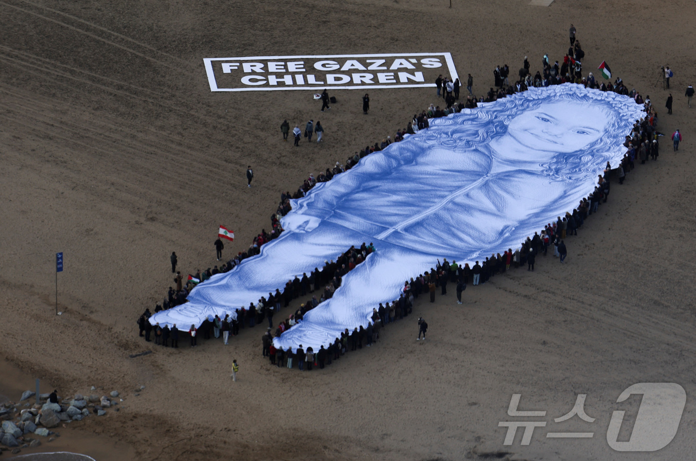 (바르셀로나 로이터=뉴스1) 김경민 기자 = 2024년 가자지구에서 사망한 5세 팔레스타인 소녀 힌드 라잡의 거대한 초상화가 29일(현지시간) 바르셀로나 바르셀로네타 해변에 펼쳐졌 …