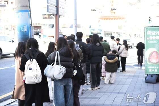 본문 이미지 - 31일 추위가 누그러진 가운데 전남 여수를 찾은 방문객들이 한 상점 앞에 줄을 서 있다. 뉴스1 김성준 기