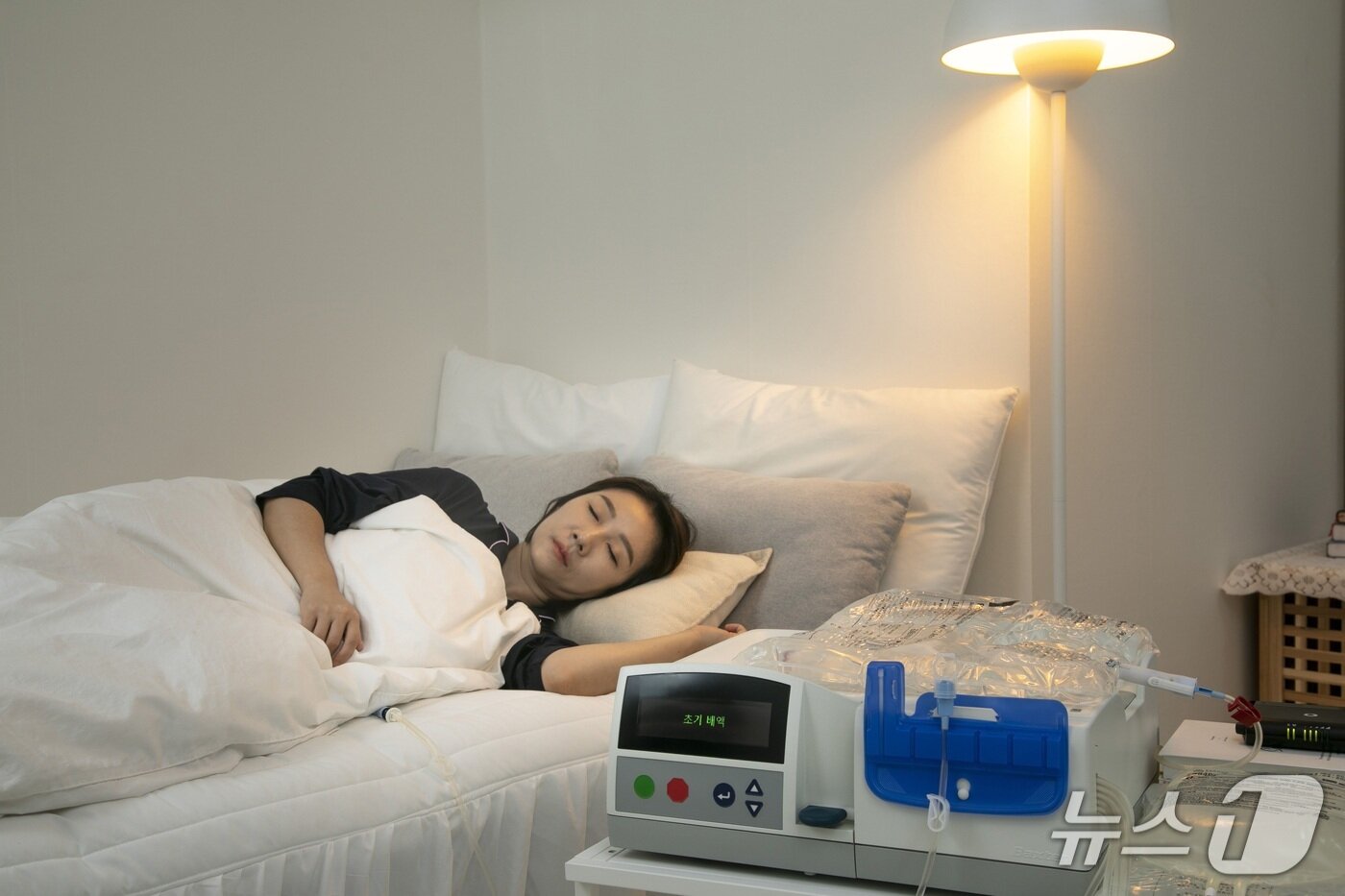 본문 이미지 - 기계를 활용한 재택 복막투석을 할 경우, 수면 중에 진행할 수 있어 깨어 있는 시간 동안 자신의 일상을 유지할 수 있다. (사진은 환자 김 씨와 무관하며, 모델의 재택 복막투석 모습이다.)/ 뉴스1 ⓒ News1