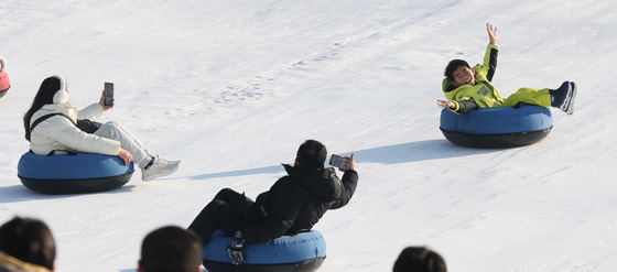 눈썰매 타는 아이, 추억을 담는 부모