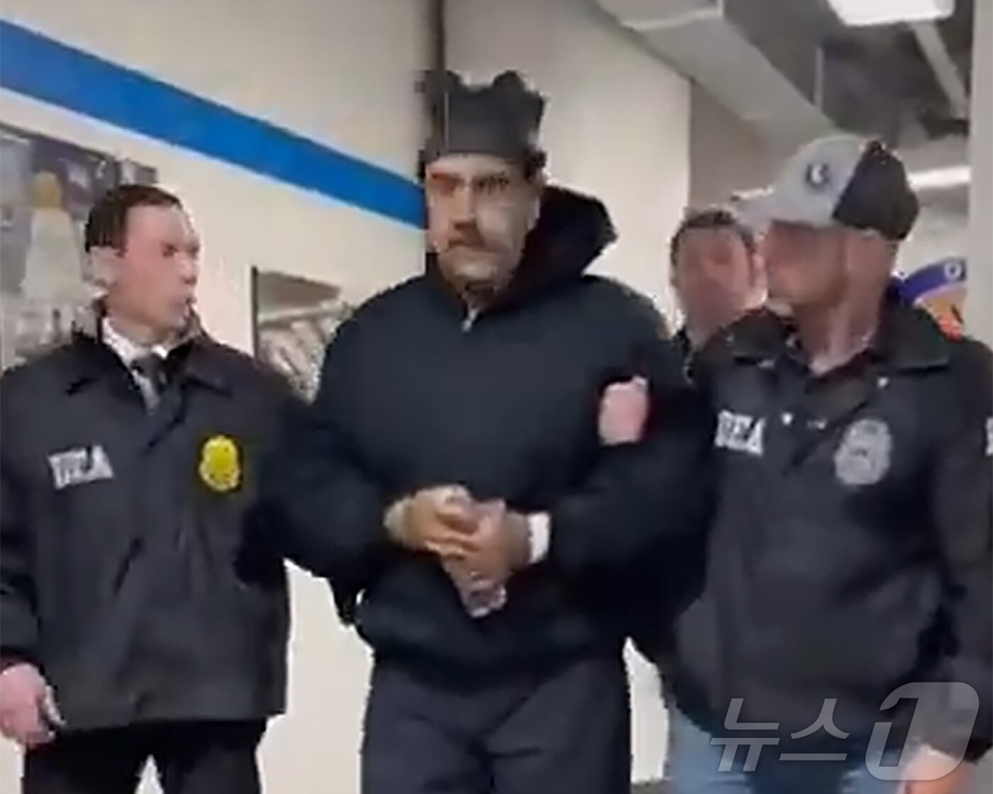 본문 이미지 - 니콜라스 마두로 베네수엘라 대통령이 3일(현지시간) 미국 마약단속국(DEA) 요원에게 이끌려 '퍼프 워크'(perp walk·수사기관이 피의자를 언론 카메라에 의도적으로 노출시키는 행위)를 하는 모습이 공개됐다. (백악관 긴급대응 엑스 계정 게시물 캡쳐) 2026.1.4/뉴스1