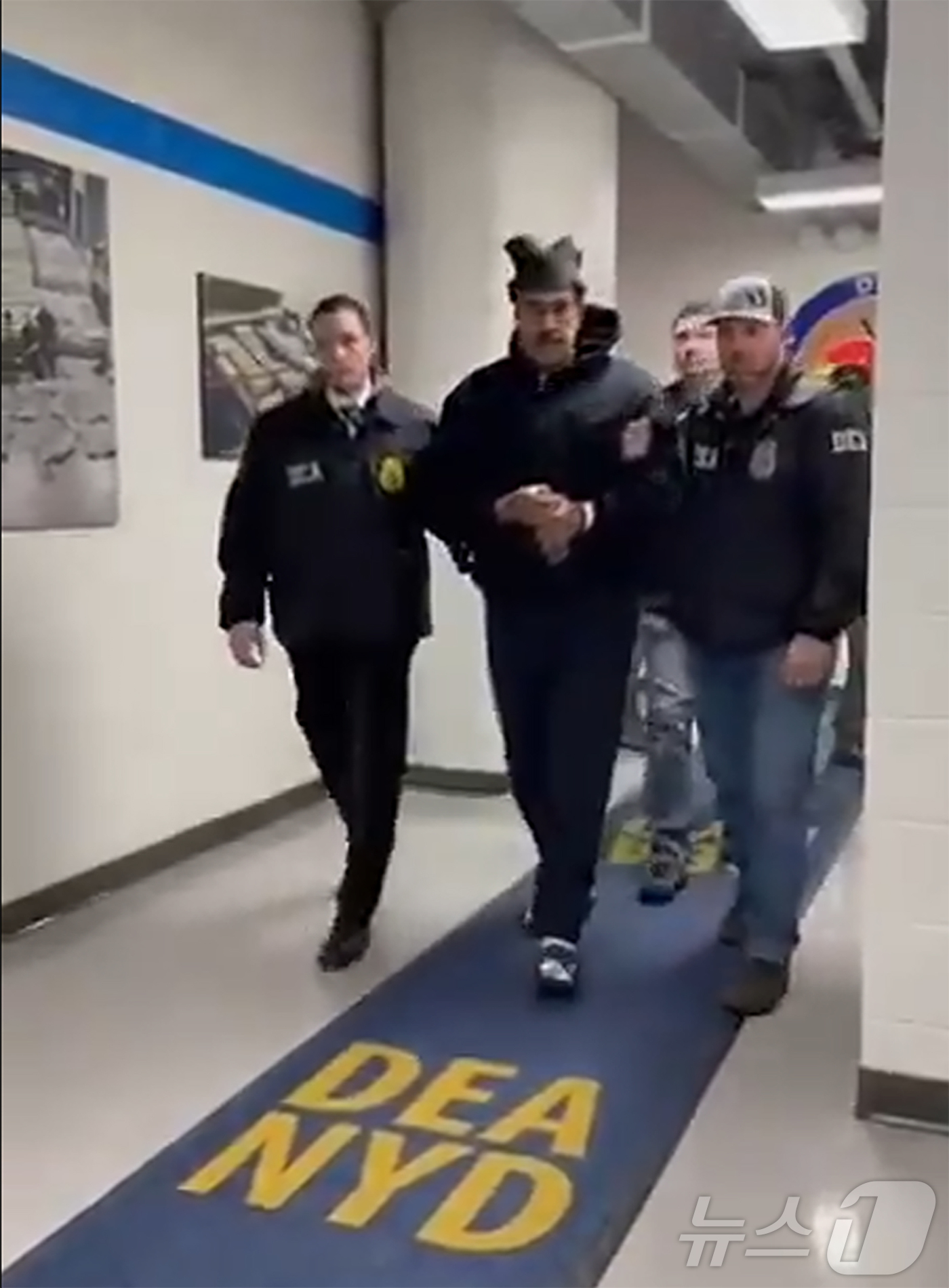 (서울=뉴스1) = 니콜라스 마두로 베네수엘라 대통령이 3일(현지시간) 미국 마약단속국(DEA) 요원에게 이끌려 '퍼프 워크'(perp walk·수사기관이 피의자를 언론 카메라에 …