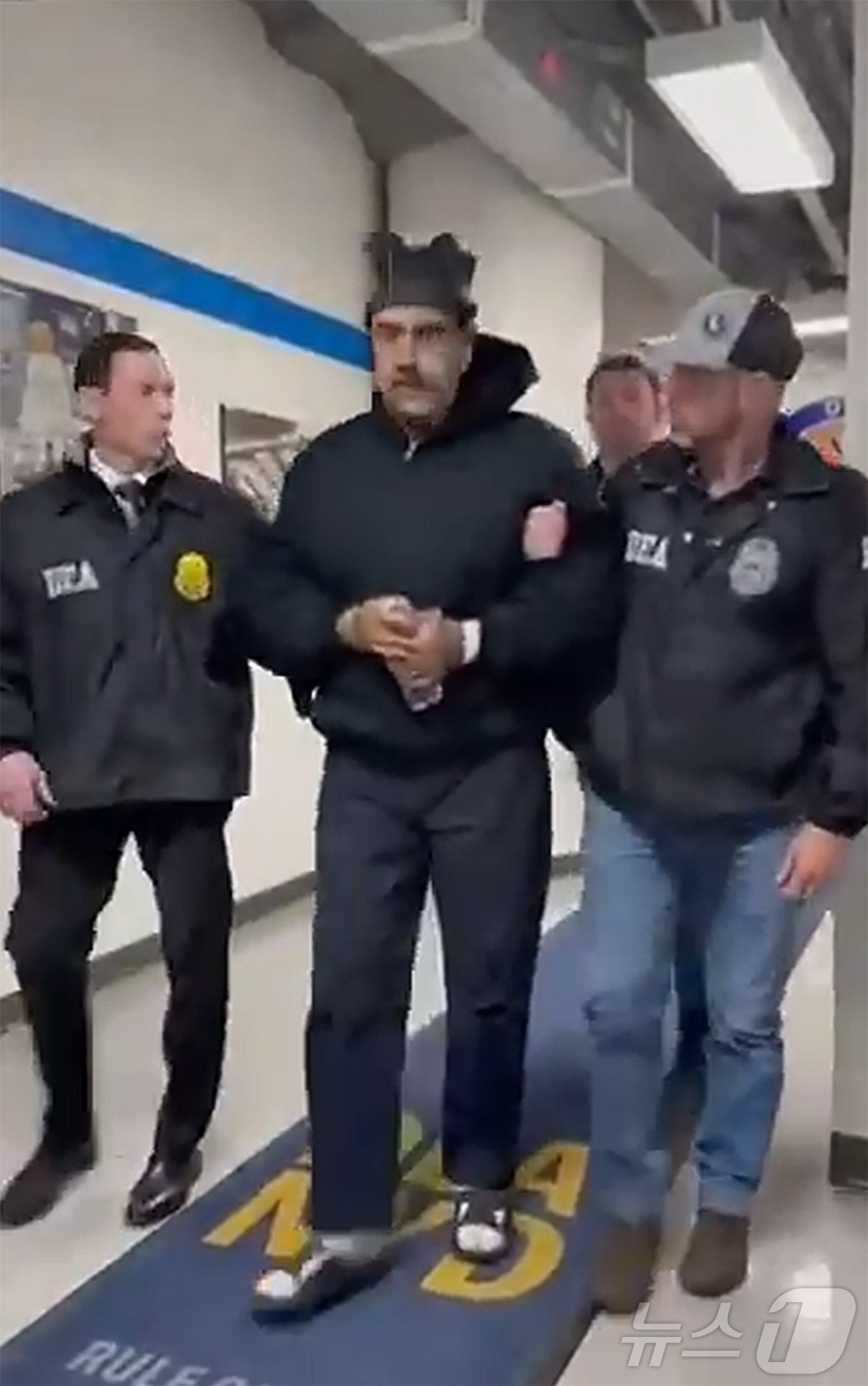 (서울=뉴스1) = 니콜라스 마두로 베네수엘라 대통령이 3일(현지시간) 미국 마약단속국(DEA) 요원에게 이끌려 '퍼프 워크'(perp walk·수사기관이 피의자를 언론 카메라에 …
