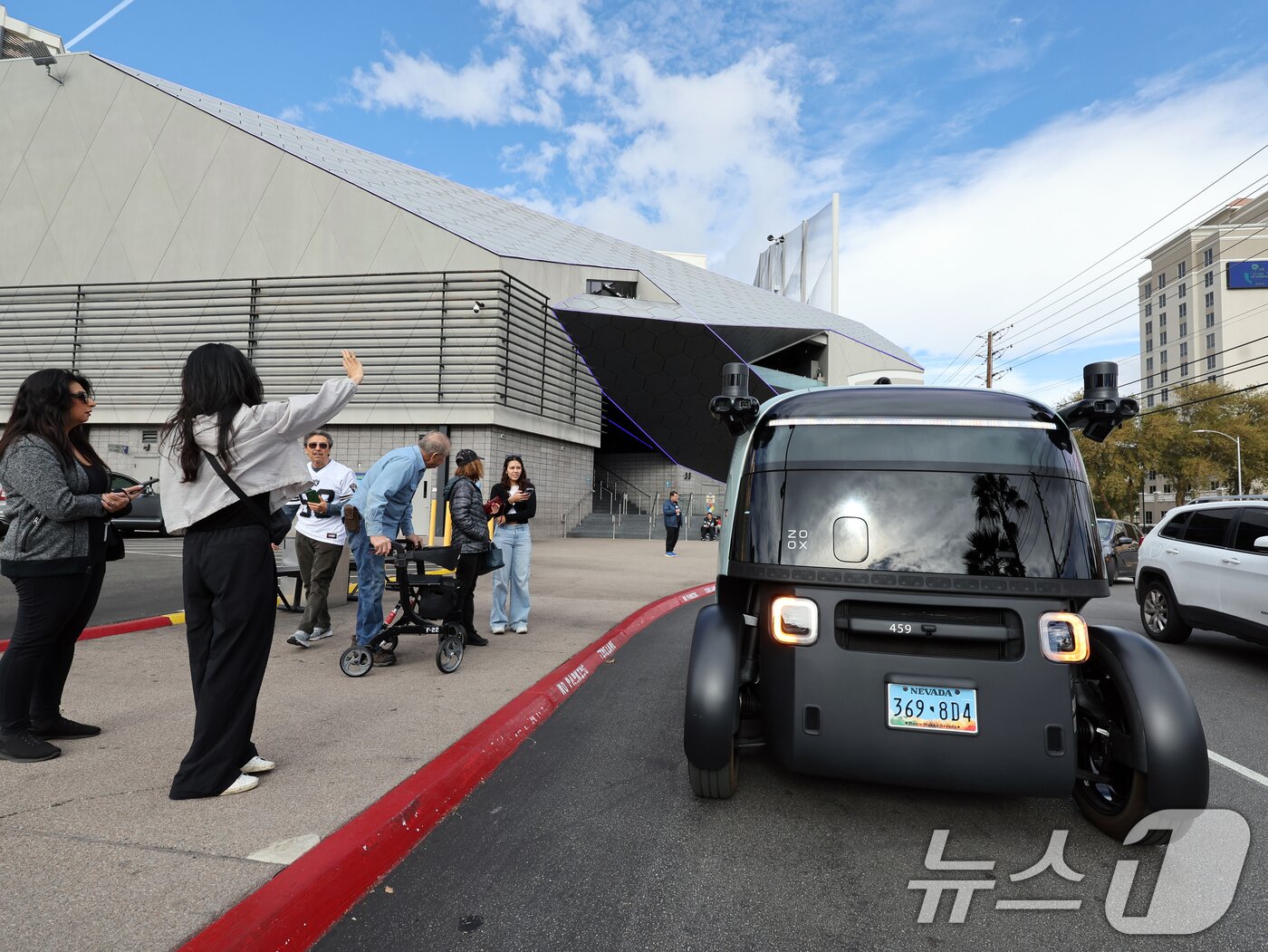 본문 이미지 - 세계 최대 IT(정보기술)·가전 전시회 'CES 2026' 개막을 이틀 앞둔 4일(현지시간) 미국 네바다주 라스베이거스 거리에서 시민들이 아마존의 로보택시 '죽스(ZOOX)'를 바라보고 있다.  2026.1.5/뉴스1 ⓒ News1 황기선 기자