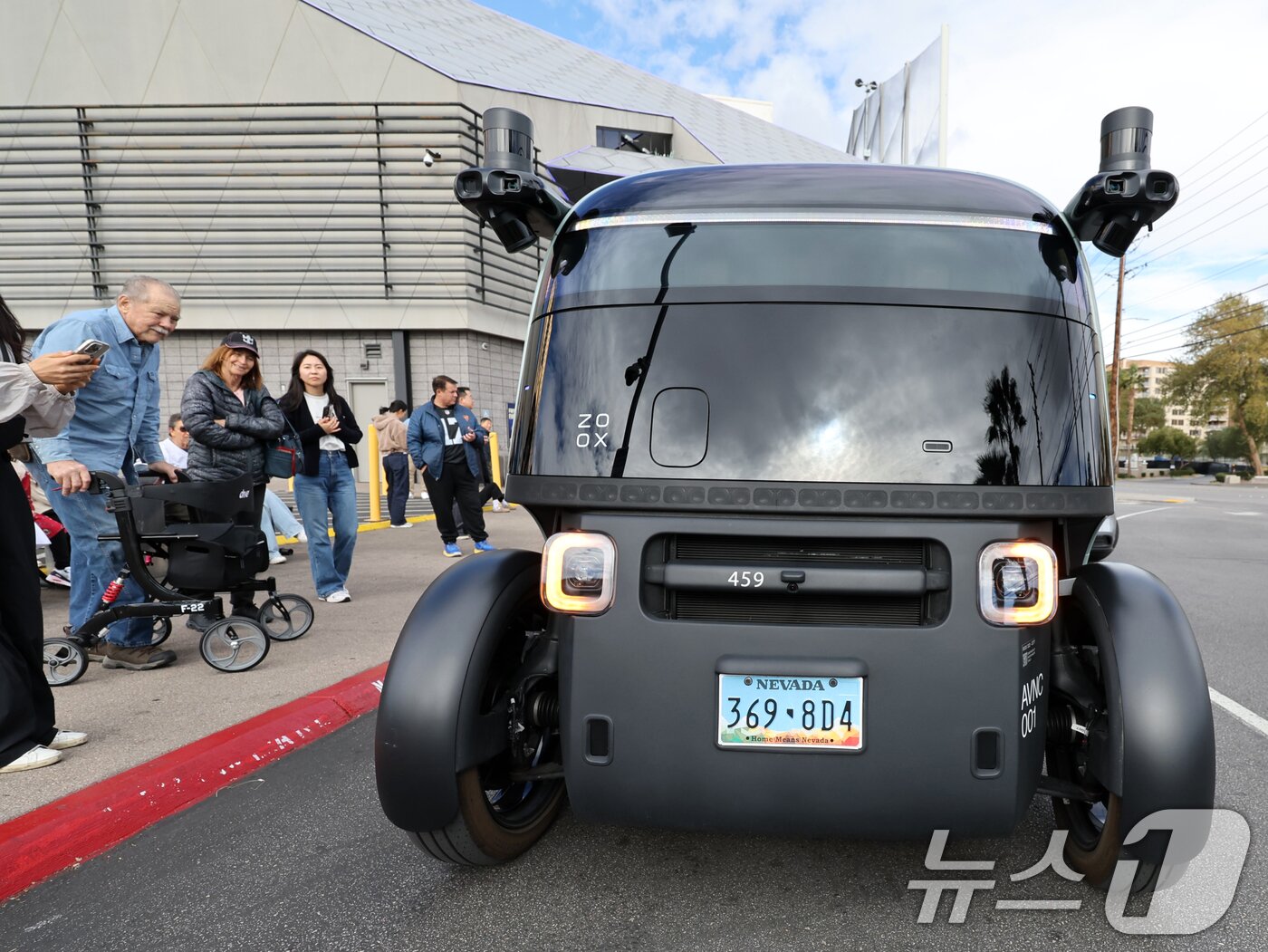 본문 이미지 - 세계 최대 IT(정보기술)·가전 전시회 'CES 2026' 개막을 이틀 앞둔 4일(현지시간) 미국 네바다주 라스베이거스 거리에서 시민들이 아마존의 로보택시 '죽스(ZOOX)'를 바라보고 있다. 2026.1.5/뉴스1 ⓒ News1 황기선 기자