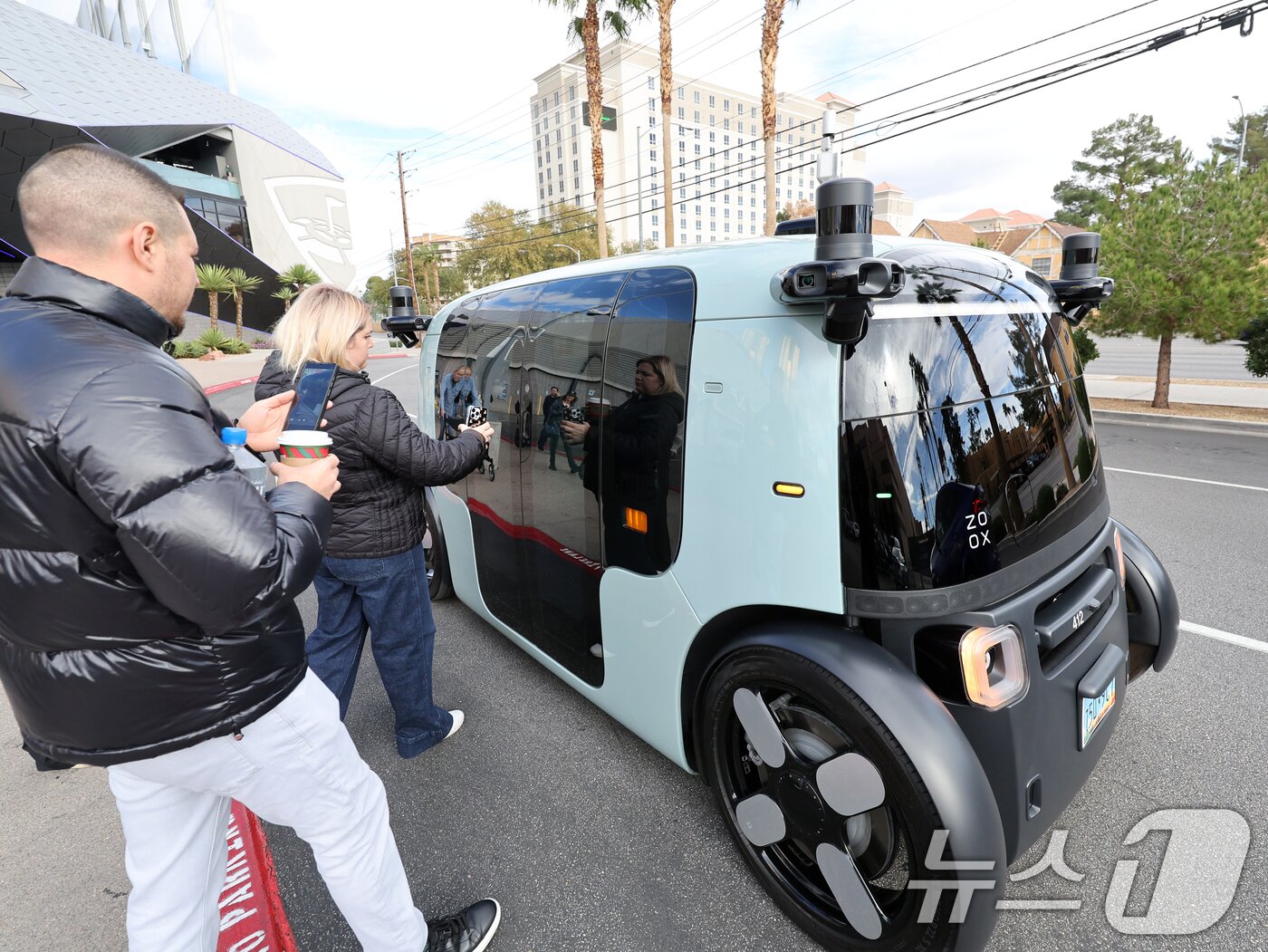 본문 이미지 - 세계 최대 IT(정보기술)·가전 전시회 'CES 2026' 개막을 이틀 앞둔 4일(현지시간) 미국 네바다주 라스베이거스 거리에서 시민들이 아마존의 로보택시 '죽스(ZOOX)'를 바라보고 있다. 2026.1.5/뉴스1 ⓒ News1 황기선 기자