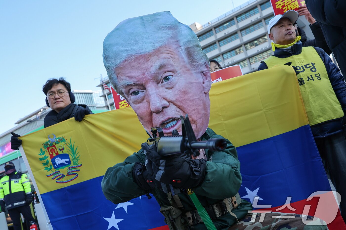 본문 이미지 - 트럼프 미국 대통령 가면을 쓴 참가자가 5일 서울 종로구 주한미국대사관 앞에서 트럼프 1년 규탄 국제민중공동행동 조직위원회 주최로 열린 ‘트럼프 베네수엘라 침공 규탄 국제민중행동 긴급 기자회견'에서 포즈를 취하고 있다. 2026.1.5/뉴스1 ⓒ News1 안은나 기자