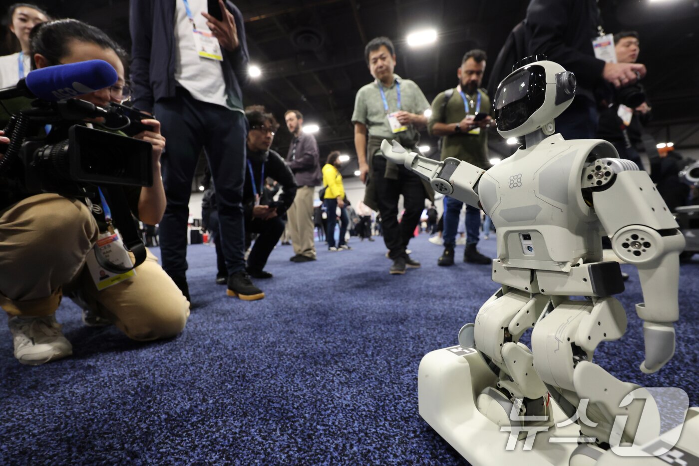 본문 이미지 - 세계 최대 IT(정보기술)·가전 전시회 'CES 2026' 개막을 이틀 앞둔 4일(현지시간) 미국 네바다주 라스베이거스 만달레이베이 호텔에서 열린 'CES 2026 언베일드'에서 관람객들이 중국기업의 휴머로이드 로봇을 살펴보고 있다. 2026.1.5/뉴스1 ⓒ News1 황기선 기자