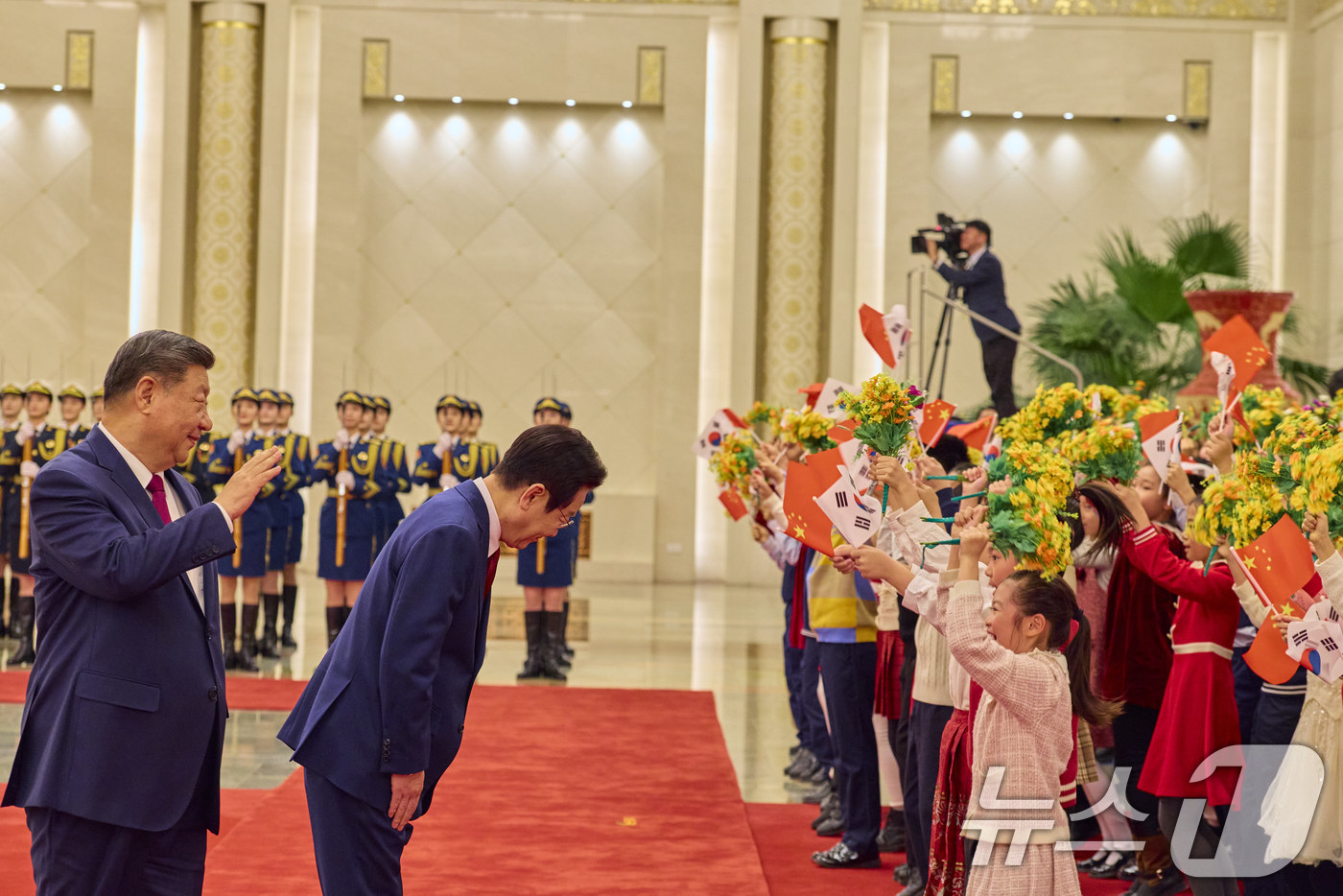 (베이징(중국)=뉴스1) 허경 기자 = 이재명 대통령과 시진핑 중국 국가주석이 5일 베이징 인민대회당에서 열린 이 대통령 공식환영식에서 어린이들을 향해 인사하고 있다. (공동취재) …