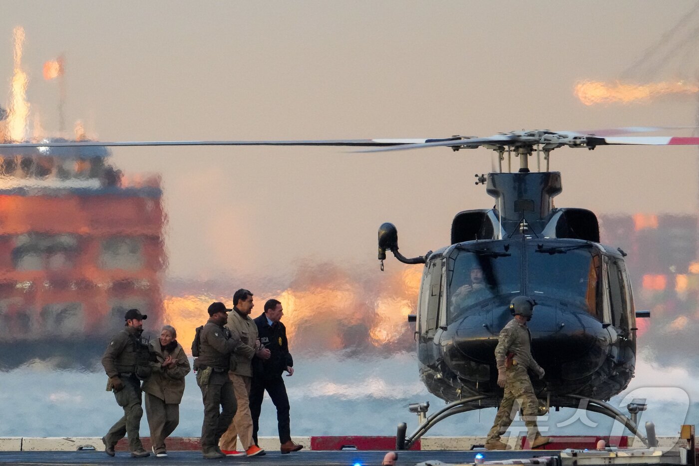 본문 이미지 - 니콜라스 마드로 베네수엘라 대통령과 부인 실리아 플로레스가 5일(현지시간) 미국 뉴욕 맨해튼에 도착한 헬기에서 내려 마약단속국(DEA) 요원들에 의해 연방 법원으로 호송되고 있다. 2026.1.5 ⓒ 로이터=뉴스1