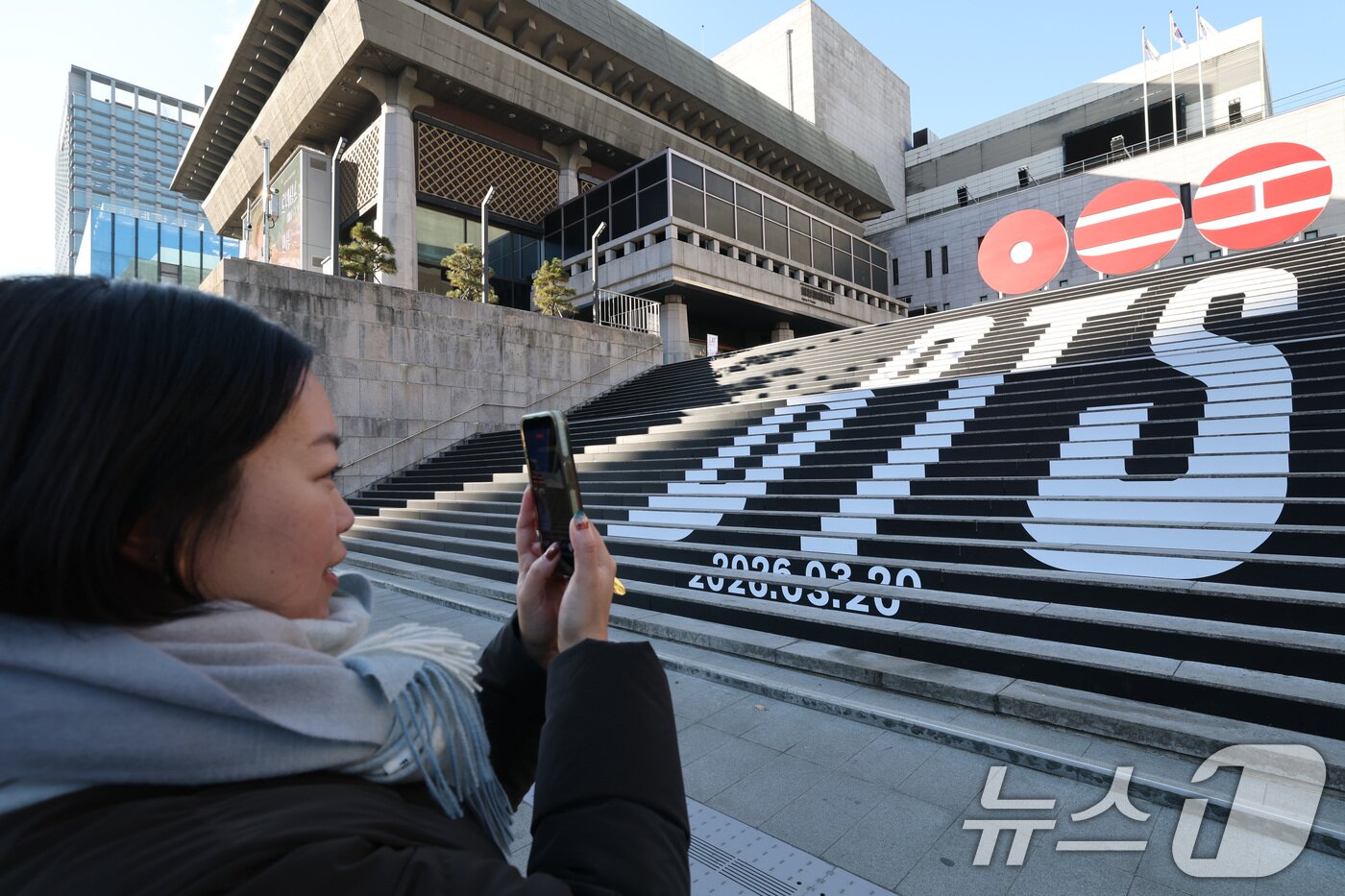 본문 이미지 - 6일 오전 서울 종로구 세종문화회관 야외 계단에 설치된 BTS(방탄소년단)의 컴백 로고 조형물 앞에서 관광객이 기념촬영을 하고 있다.  2026.1.6/뉴스1 ⓒ News1 임세영 기자