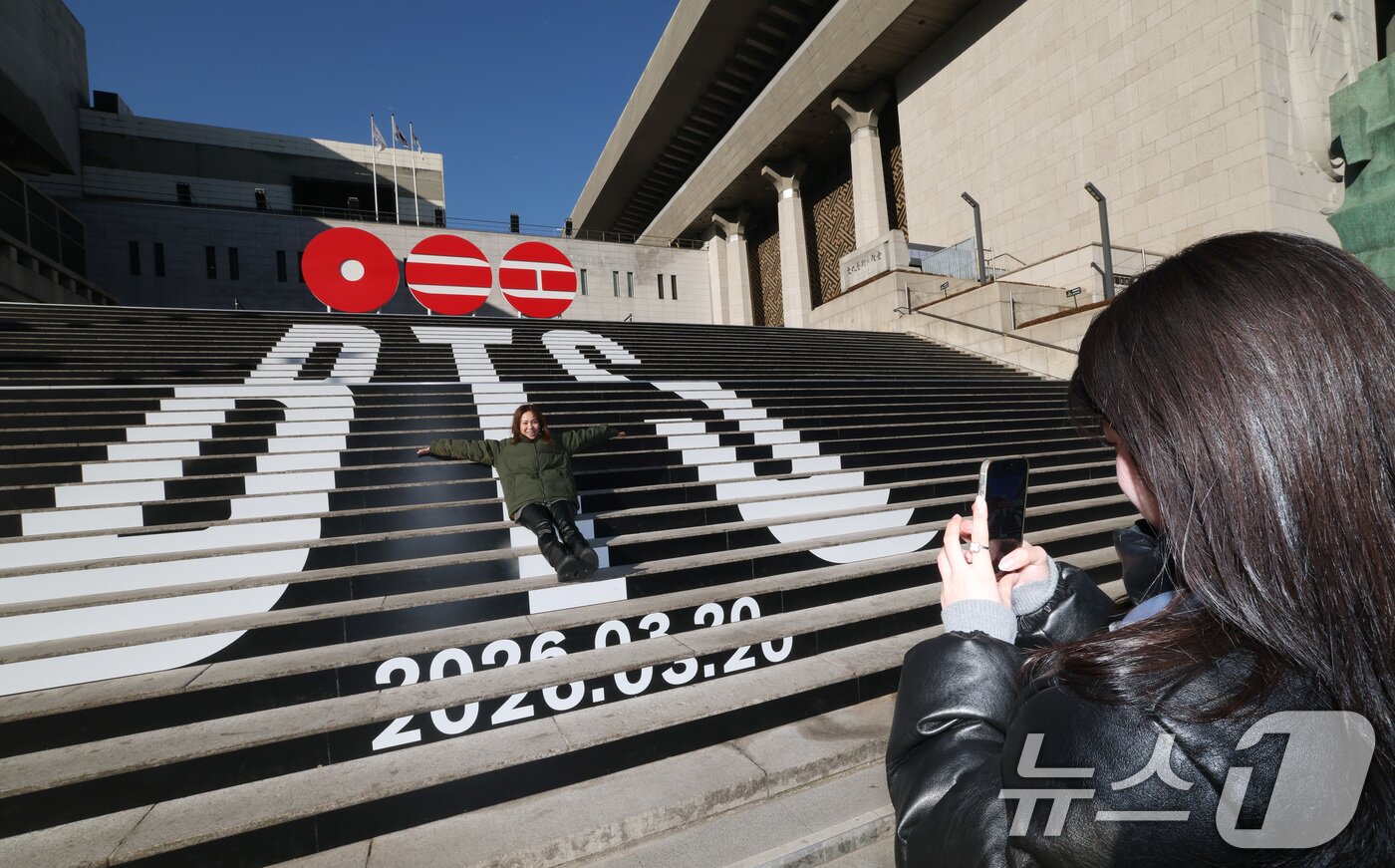 본문 이미지 - 6일 오전 서울 종로구 세종문화회관 야외 계단에 설치된 BTS(방탄소년단)의 컴백 로고 조형물 앞에서 관광객들이 기념촬영을 하고 있다.  2026.1.6/뉴스1 ⓒ News1 임세영 기자