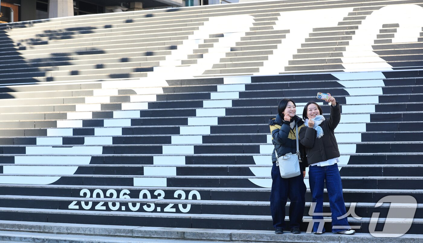본문 이미지 - 6일 오전 서울 종로구 세종문화회관 야외 계단에 설치된 BTS(방탄소년단)의 컴백 로고 조형물 앞에서 관광객들이 기념촬영을 하고 있다.  2026.1.6/뉴스1 ⓒ News1 임세영 기자