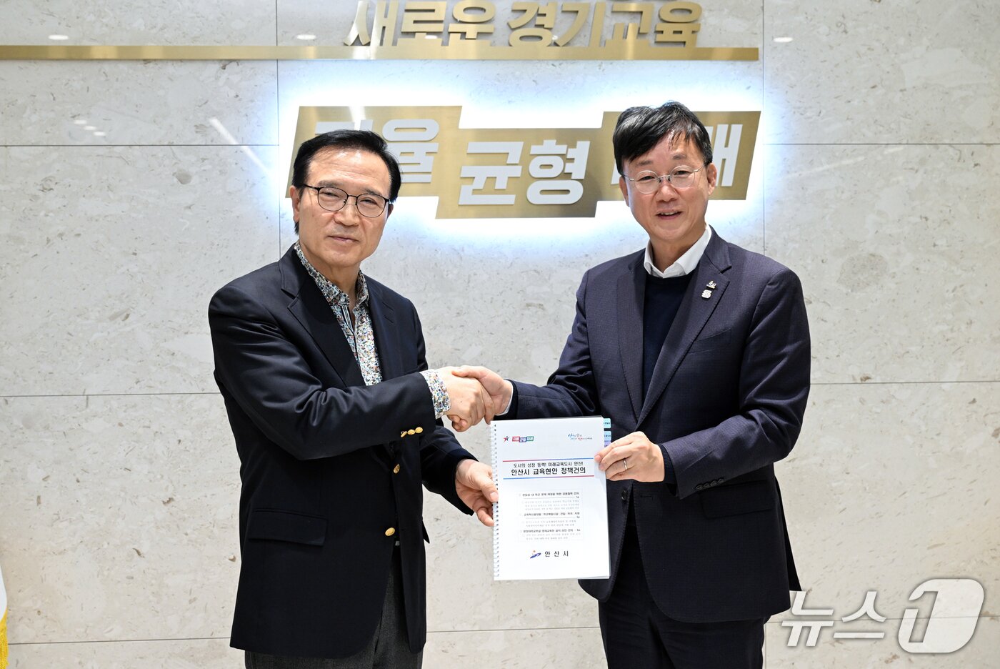 본문 이미지 - 이민근 안산시장(오른쪽)이 임태희 경기도교육감에게 교육발전을 위한 정책건의서를 전달하는 모습.(안산시 제공)