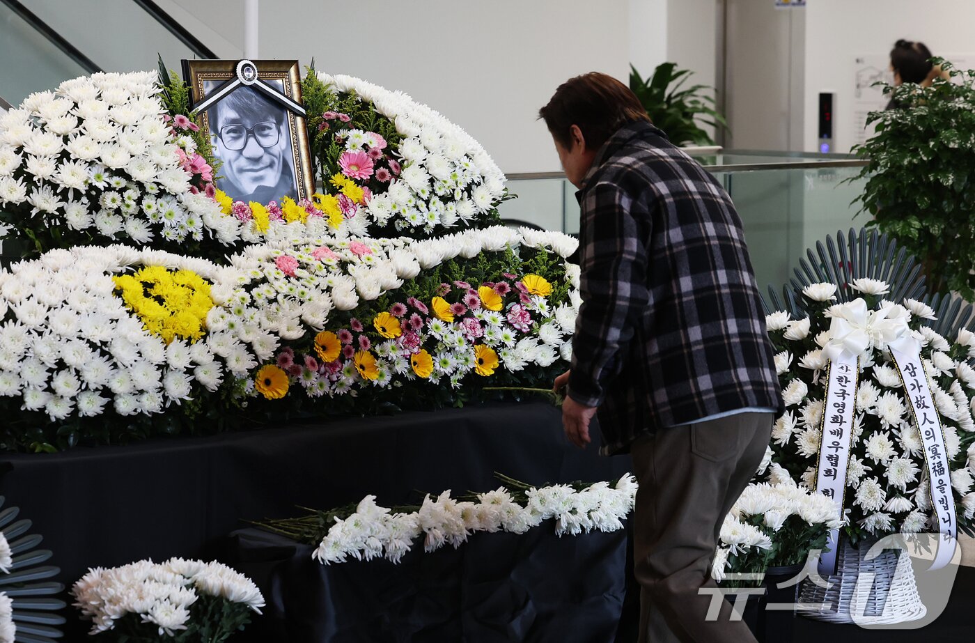 본문 이미지 - 6일 오후 서울 중구 서울영화센터에 마련된 '국민배우' 고 안성기 시민 추모공간을 찾은 시민들이 고인의 영정에 헌화하고 있다. 2026.1.6/뉴스1 ⓒ News1 오대일 기자