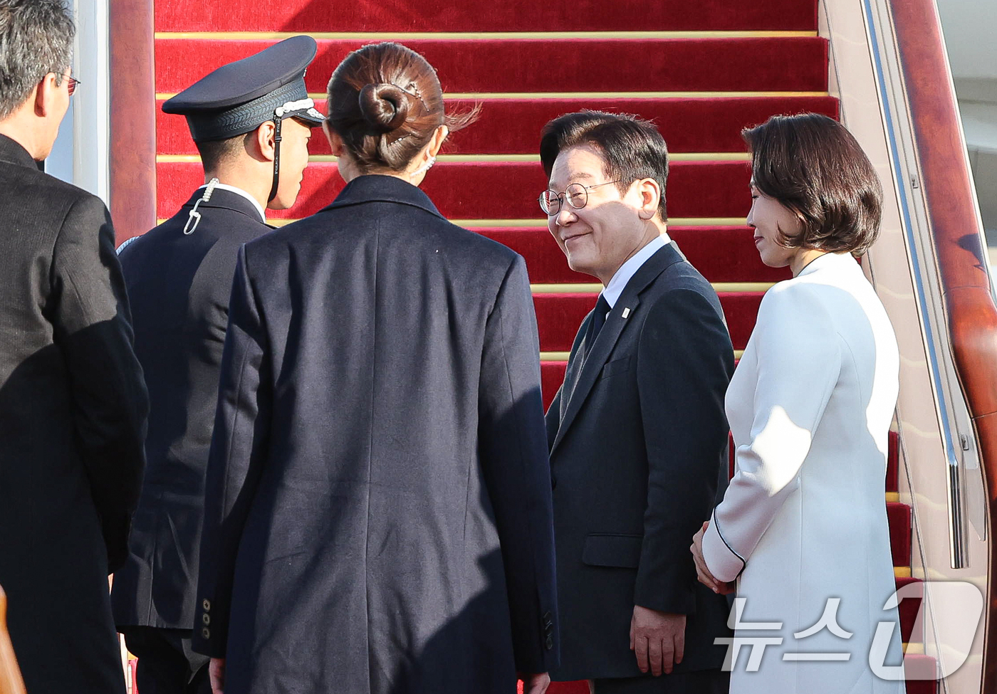 (베이징(중국)=뉴스1) 허경 기자 = 중국을 국빈방문 중인 이재명 대통령과 김혜경 여사가 6일 베이징 서우두 공항에서 상하이행 공군 1호기 탑승 전 환송객과 인사하고 있다. 20 …