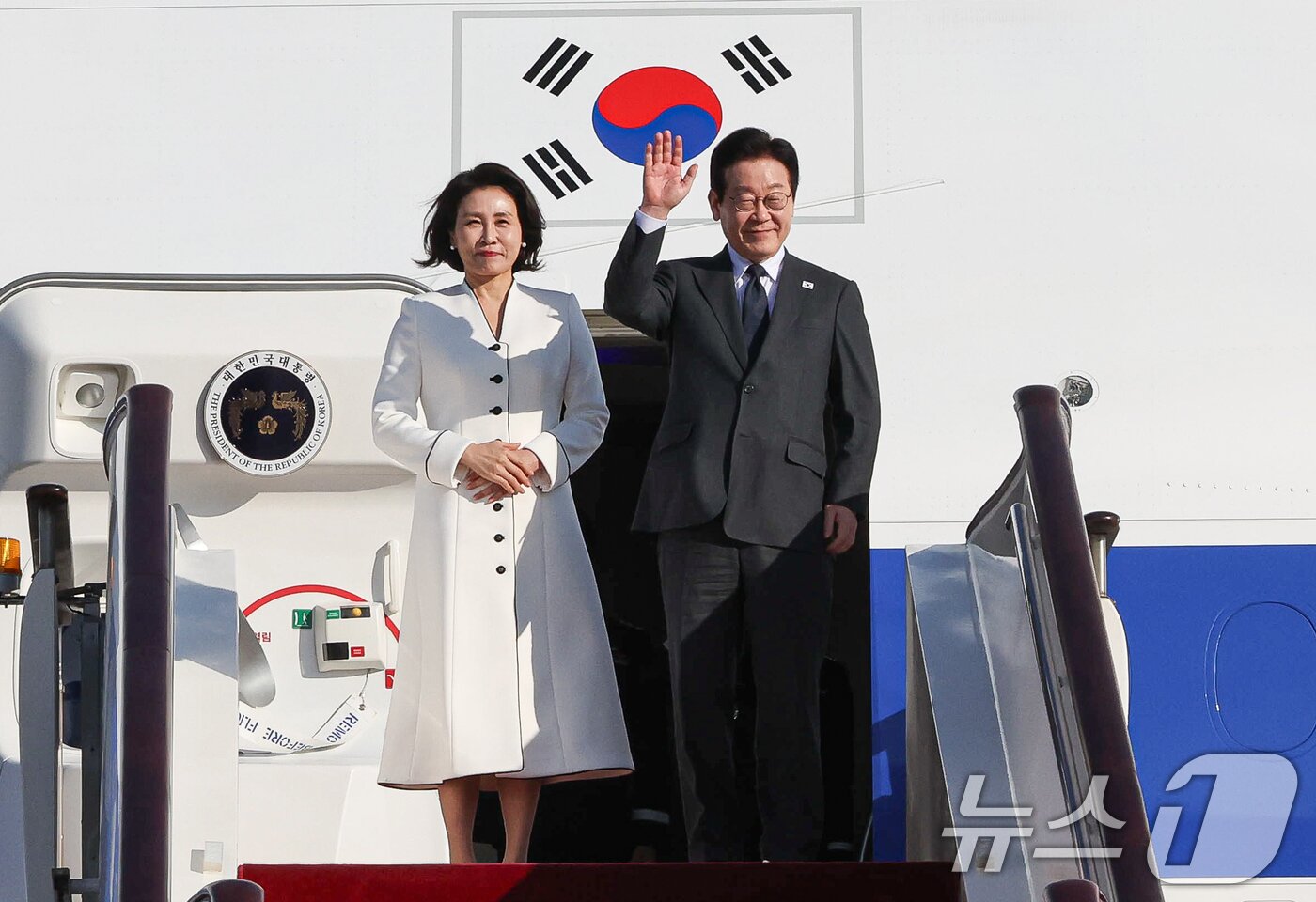 본문 이미지 - 중국을 국빈방문 중인 이재명 대통령과 김혜경 여사가 6일 베이징 서우두 공항 상하이행 공군 1호기에서 환송객에게 인사하고 있다. 2026.1.6/뉴스1 ⓒ News1 허경 기자