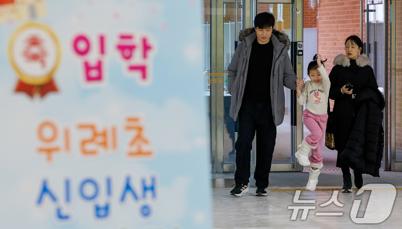 (서울=뉴스1) 안은나 기자 = 2026학년도 초등학교 신입생 예비소집일인 6일 오후 서울 강동구 위례초등학교를 찾은 예비 초등학교 1학년생이 부모님과 함께 교실로 향하고 있다. …
