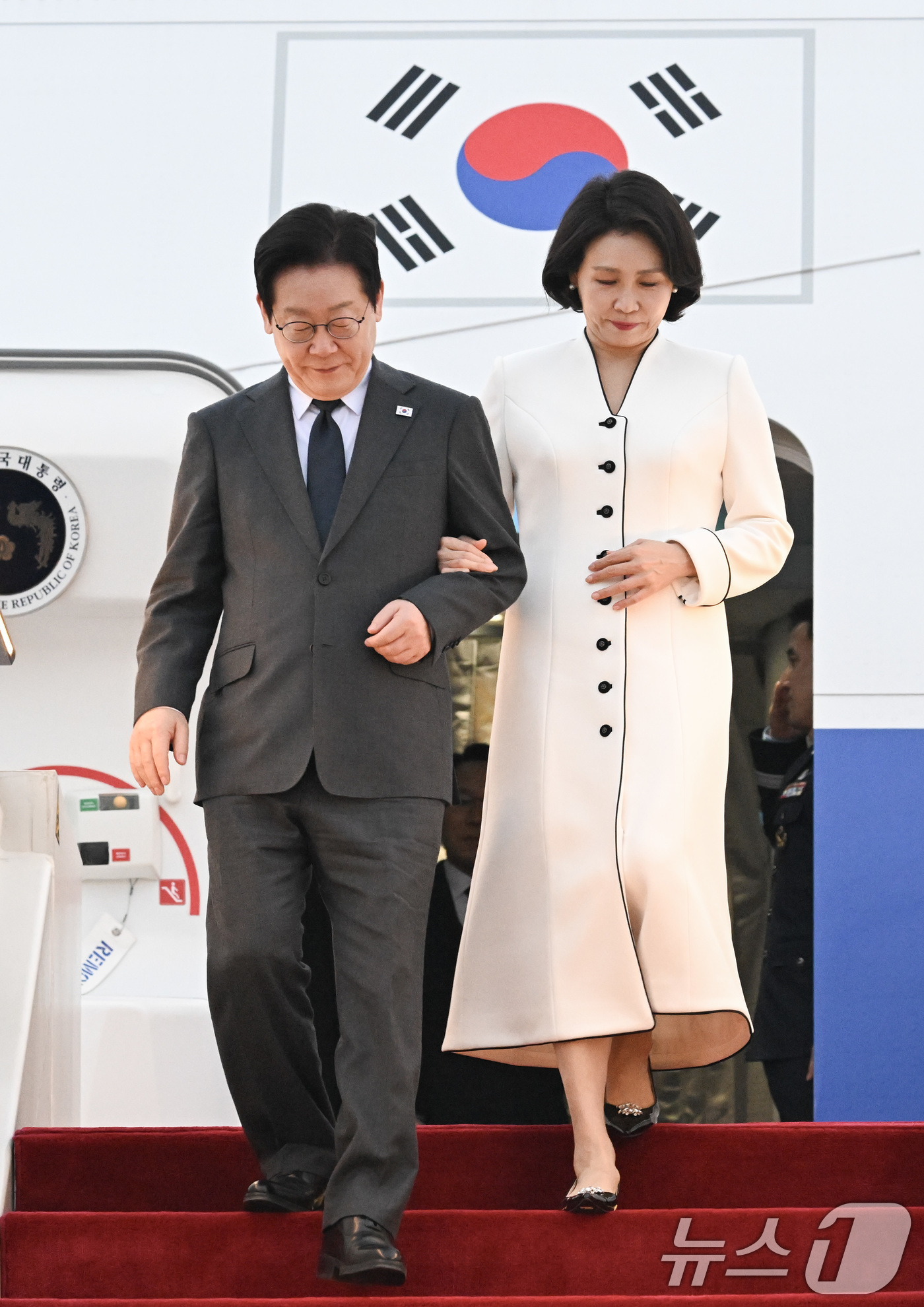 (상하이(중국)=뉴스1) 허경 기자 = 중국을 국빈방문 중인 이재명 대통령과 김혜경 여사가 6일 상하이 푸동 공항에 도착한 공군 1호기에서 내려 이동하고 있다.  2026.1.6/ …
