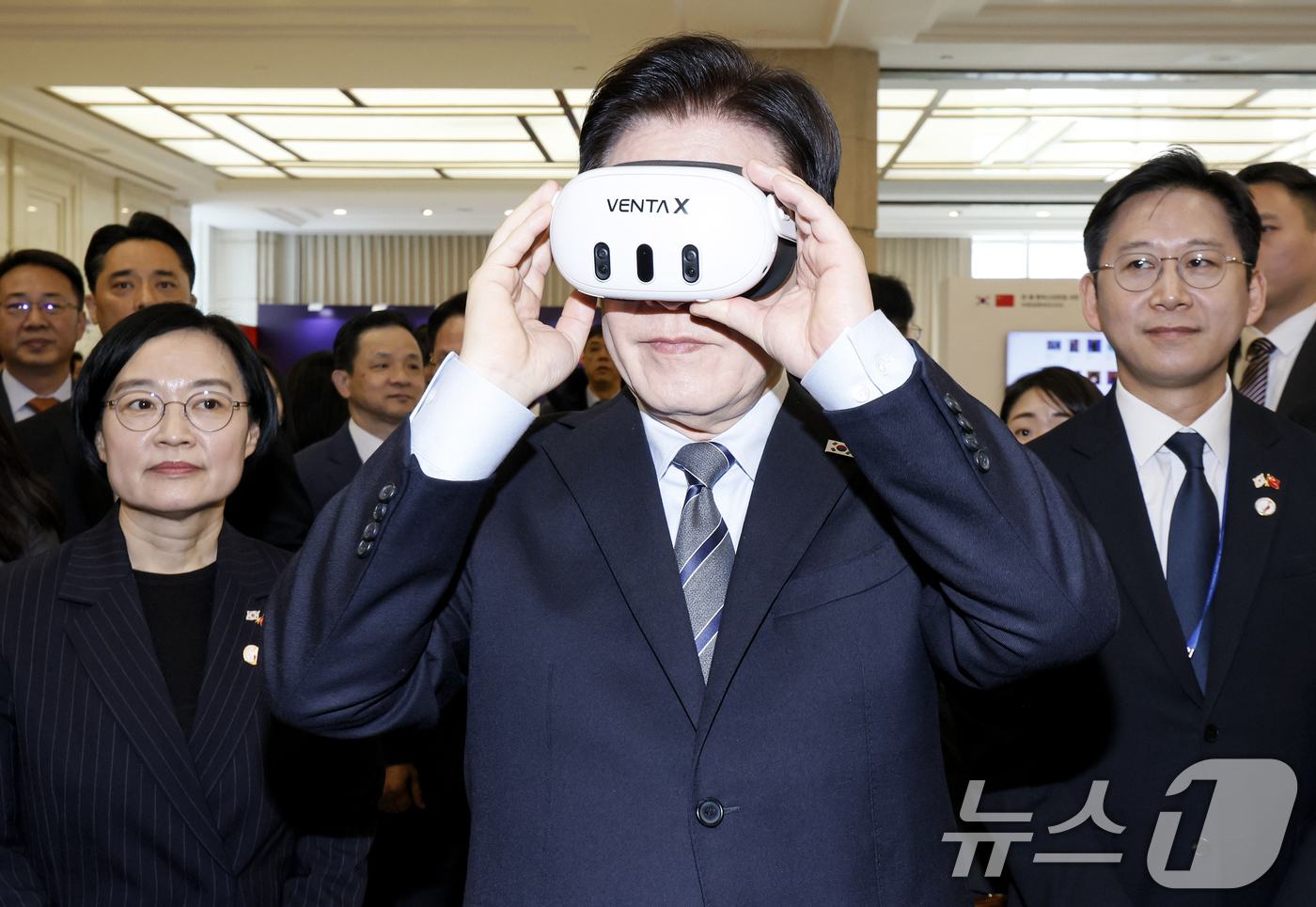 (상하이(중국)=뉴스1) 허경 기자 = 이재명 대통령이 7일 중국 상하이 국제회의중심에서 열린 한중 벤처스타트업 서밋 행사에서 VR기기 벤타X를 체험하고 있다.  2026.1.7/ …