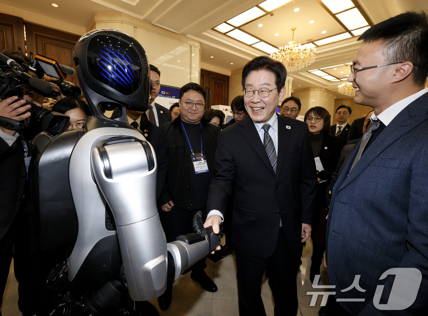 (상하이(중국)=뉴스1) 허경 기자 = 이재명 대통령이 7일 중국 상하이 국제회의중심에서 열린 한중 벤처스타트업 서밋 행사에서 중국 기업 엣지봇의 휴머노이드 로봇을 살펴보고 있다. …