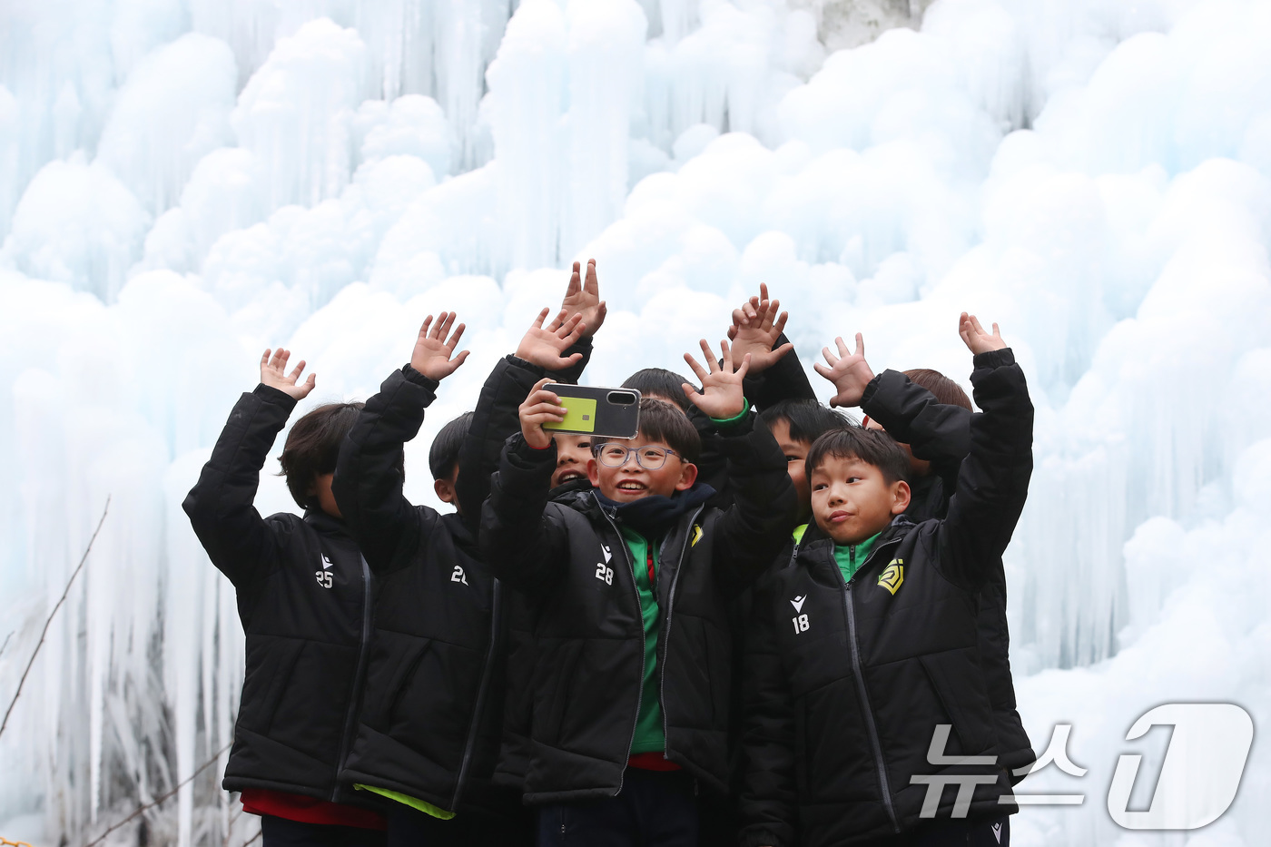 (대구=뉴스1) 공정식 기자 = 7일 오후 대구 달성군 유가읍 비슬산자연휴양림 얼음동산을 찾은 순천중앙초등학교 축구부 어린들이 꽁꽁 언 빙벽 앞에서 기념촬영을 하고 있다. 2026 …