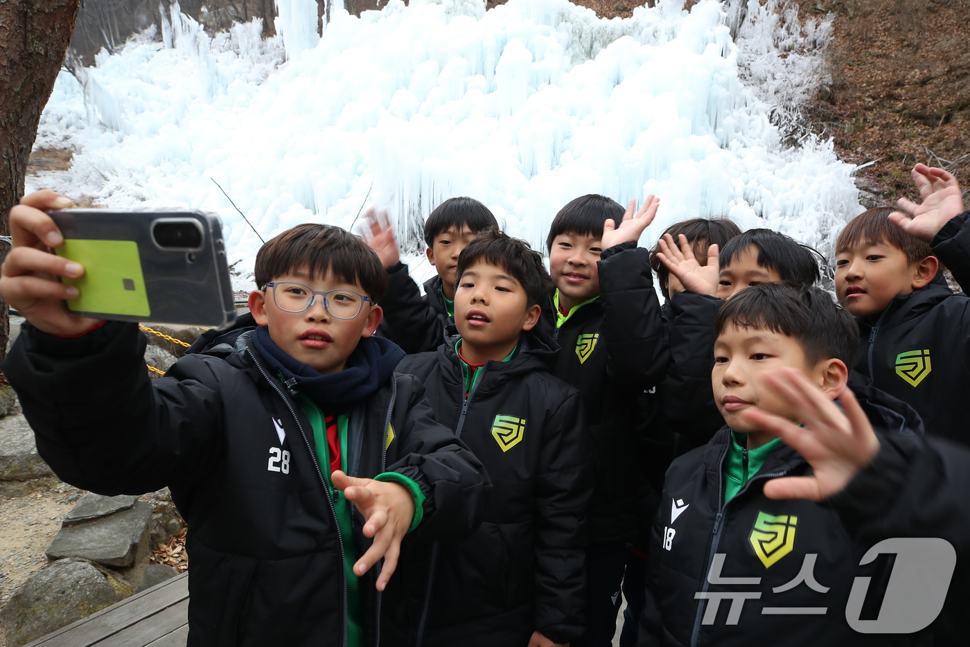 (대구=뉴스1) 공정식 기자 = 7일 오후 대구 달성군 유가읍 비슬산자연휴양림 얼음동산을 찾은 순천중앙초등학교 축구부 어린들이 꽁꽁 언 빙벽 앞에서 기념촬영을 하고 있다. 2026 …