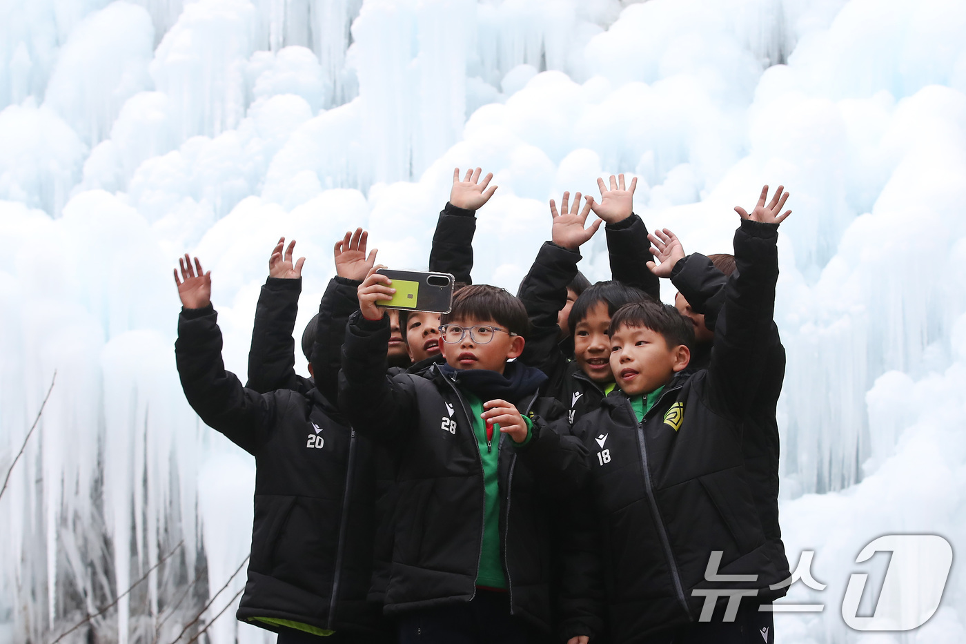 (대구=뉴스1) 공정식 기자 = 7일 오후 대구 달성군 유가읍 비슬산자연휴양림 얼음동산을 찾은 순천중앙초등학교 축구부 어린들이 꽁꽁 언 빙벽 앞에서 기념촬영을 하고 있다. 2026 …