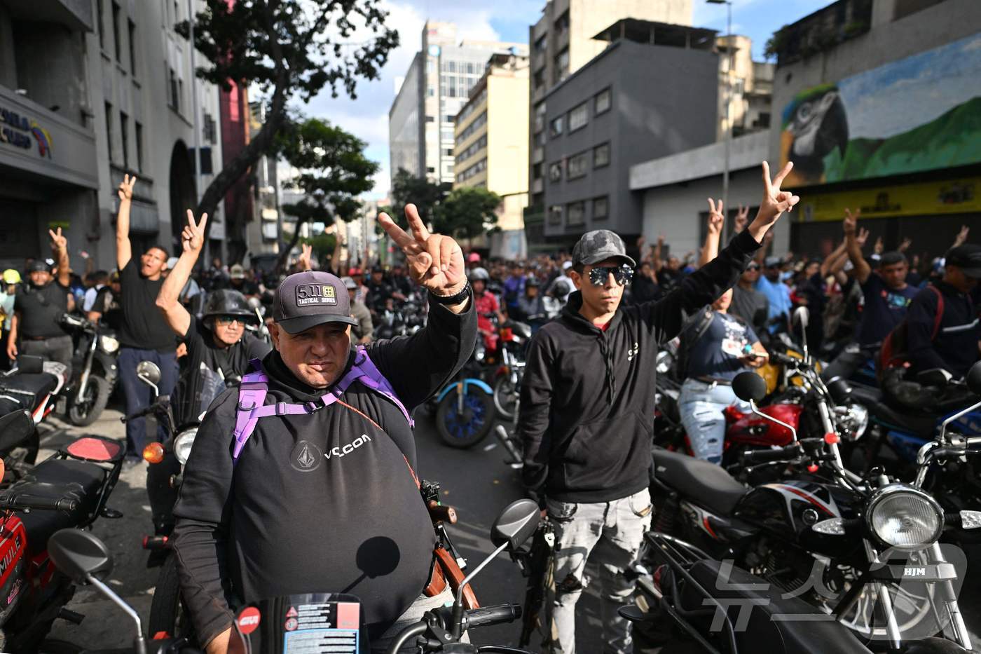 본문 이미지 - 니콜라스 마두로 베네수엘라 대통령이 체포된 다음 날인 4일(현지시간) 베네수엘라 카라카스에서 마두로 지지자들이 오토바이를 타고 'V'자 손짓을 하고 있다. 2026.01.04. ⓒ AFP=뉴스1 ⓒ News1 이정환 기자