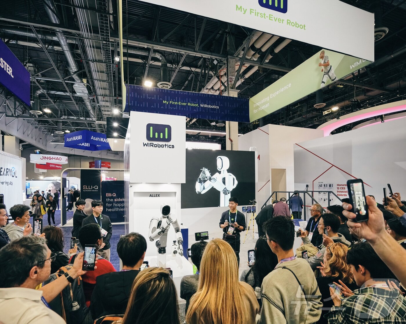 본문 이미지 - 지난 6일(현지시간) 미국 라스베이거스에서 열린 CES 2026 위로보틱스 부스 전면에서 휴머노이드 로봇 시연이 진행되자 관람객들이 발길을 멈추고 시연 장면을 지켜보고 있다. 현장에서는 로봇의 동작과 기능 설명이 이어지며 위로보틱스의 휴머노이드 로봇 기술에 대한 관람객들의 관심이 집중됐다. (위로보틱스 제공. 재판매 및 DB 금지) 2026.1.8/뉴스1