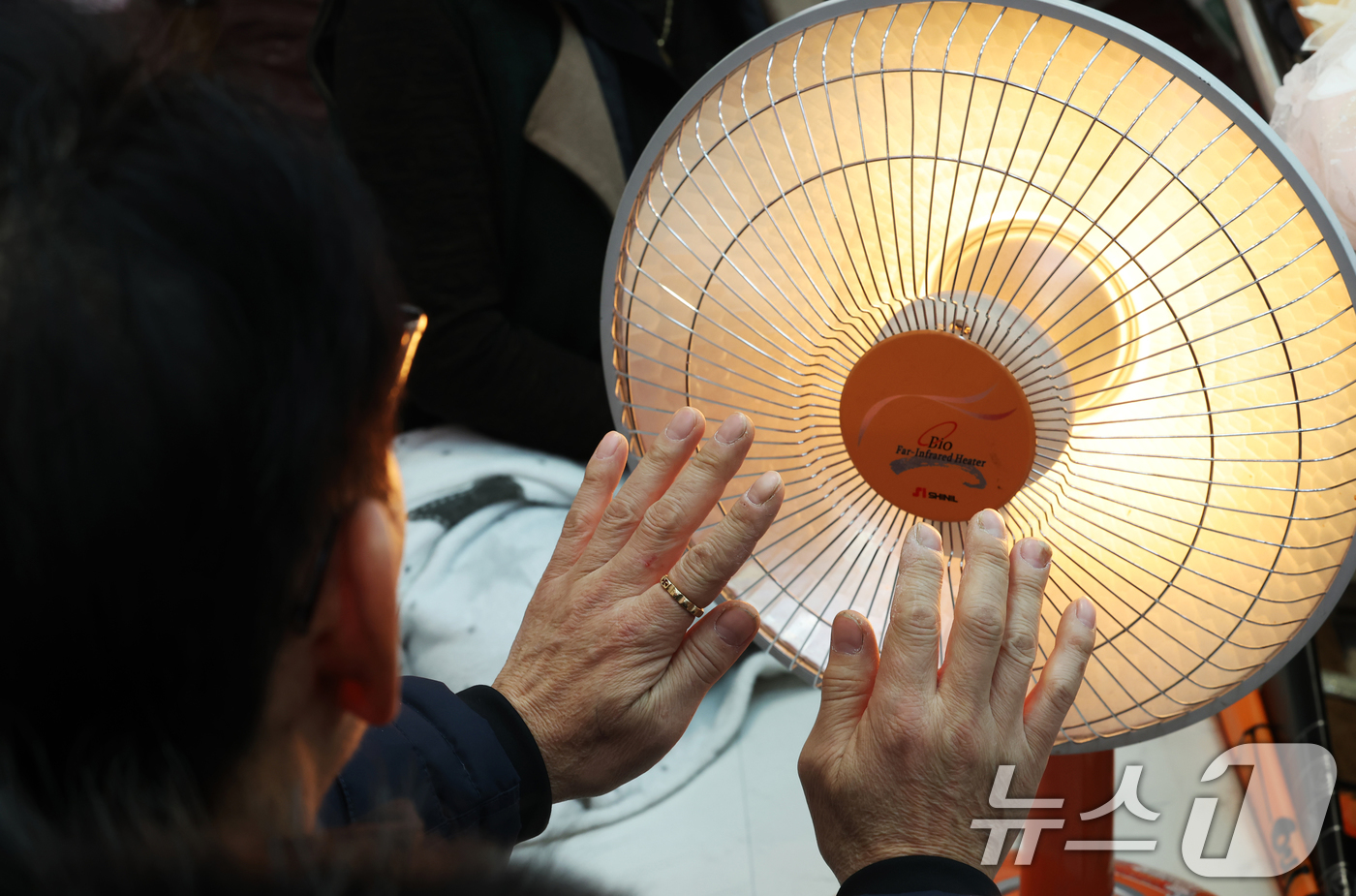 (수원=뉴스1) 김영운 기자 = 전국 대부분 지역에 영하권 추위를 보인 8일 경기 수원시 팔달구 영동시장에서 상인들이 전기난로에 몸을 녹이고 있다. 2026.1.8/뉴스1