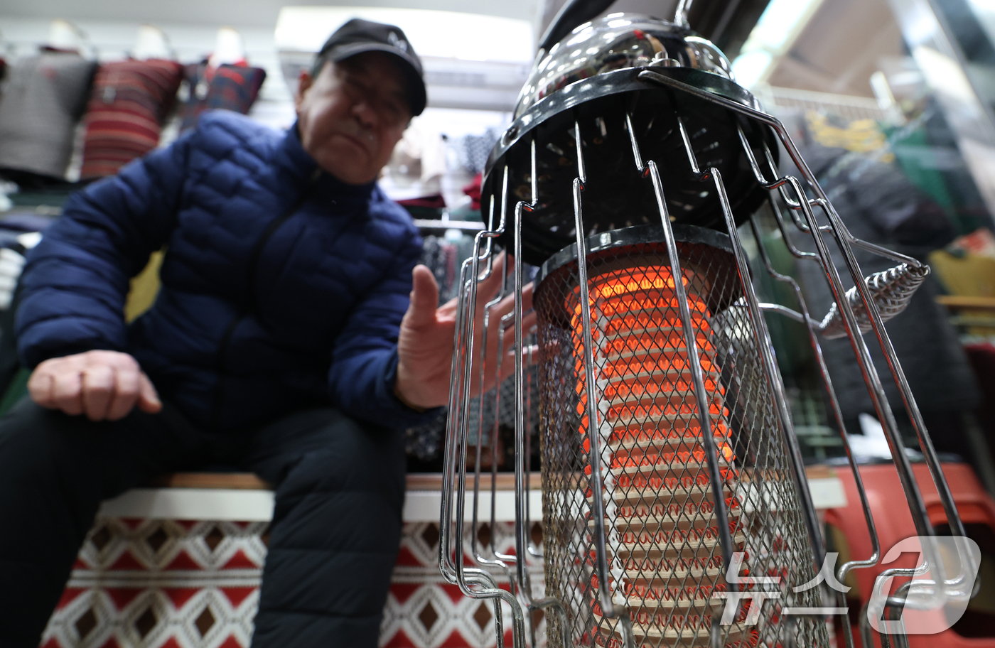 (수원=뉴스1) 김영운 기자 = 전국 대부분 지역에 영하권 추위를 보인 8일 경기 수원시 팔달구 영동시장에서 상인들이 전기난로에 몸을 녹이고 있다. 2026.1.8/뉴스1