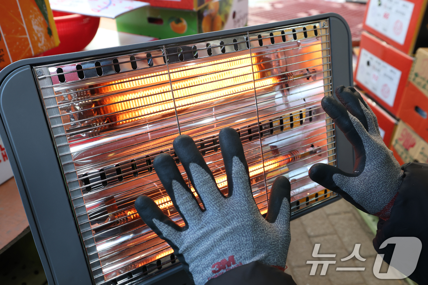 (수원=뉴스1) 김영운 기자 = 전국 대부분 지역에 영하권 추위를 보인 8일 경기 수원시 팔달구 영동시장에서 상인들이 전기난로에 몸을 녹이고 있다. 2026.1.8/뉴스1