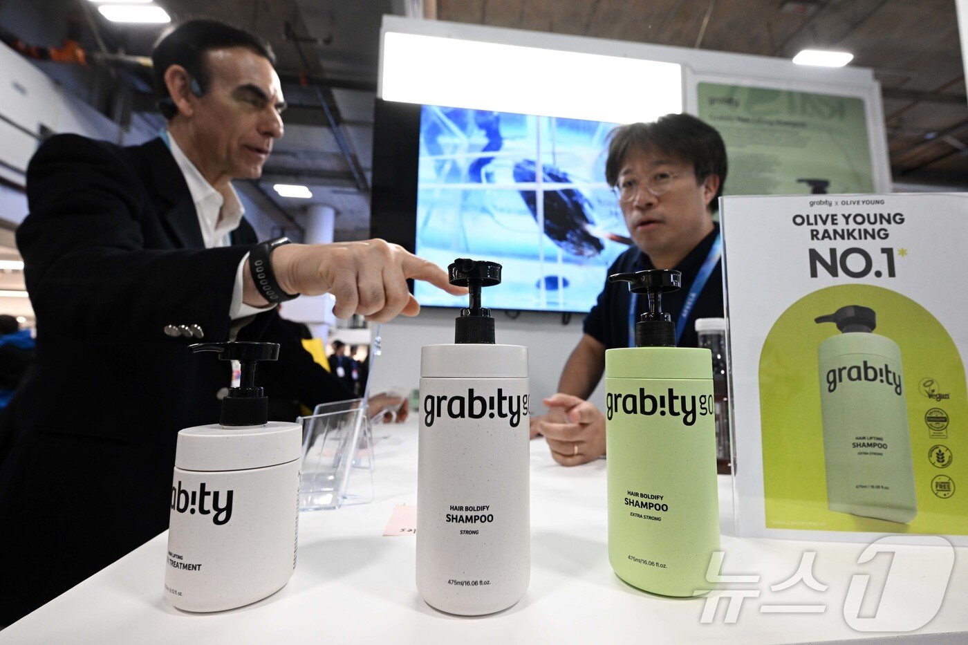 본문 이미지 - 세계 최대 가전·정보기술(IT) 전시회 'CES 2026' 이틀째인 7일(현지시간) 미국 네바다주 라스베이거스 베네치안엑스포 내 유레카파크에서 관람객이 KAIST 연구진이 개발한 탈모 기능성 샴푸 '그래비티'에 대한 설명을 듣고 있다. (그래비티 제공. 재판매 및 DB 금지) 2026.1.8/뉴스1