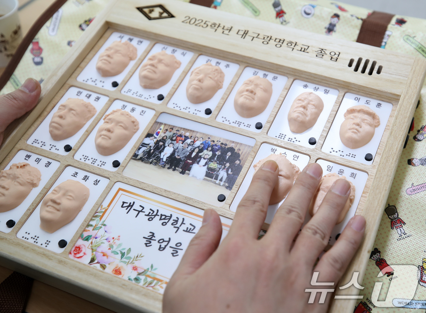 (대구=뉴스1) 공정식 기자 = 8일 오전 대구 남구 대명동 시각장애인 교육기관 대구광명학교의 2025학년도 졸업식에서 3D 프린터로 제작된 졸업앨범을 받은 졸업생이 친구들의 얼굴 …