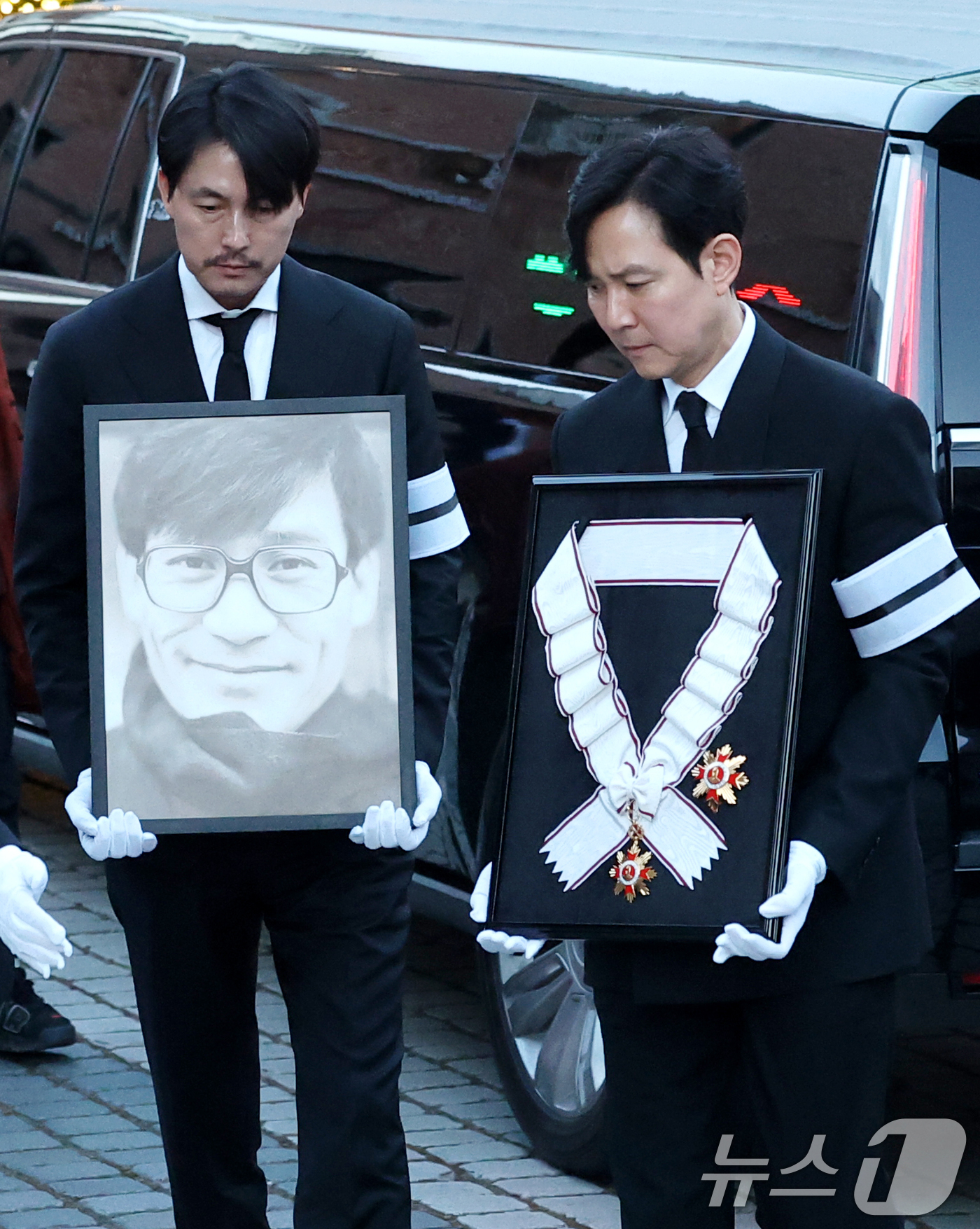 (서울=뉴스1) 권현진 기자 = 배우 정우성과 이정재가 故 안성기의 장례 미사를 위해 9일 오전 서울 중구 명동성당으로 들어서고 있다. 정우성은 고인의 영정을, 이정재는 금관문화훈 …