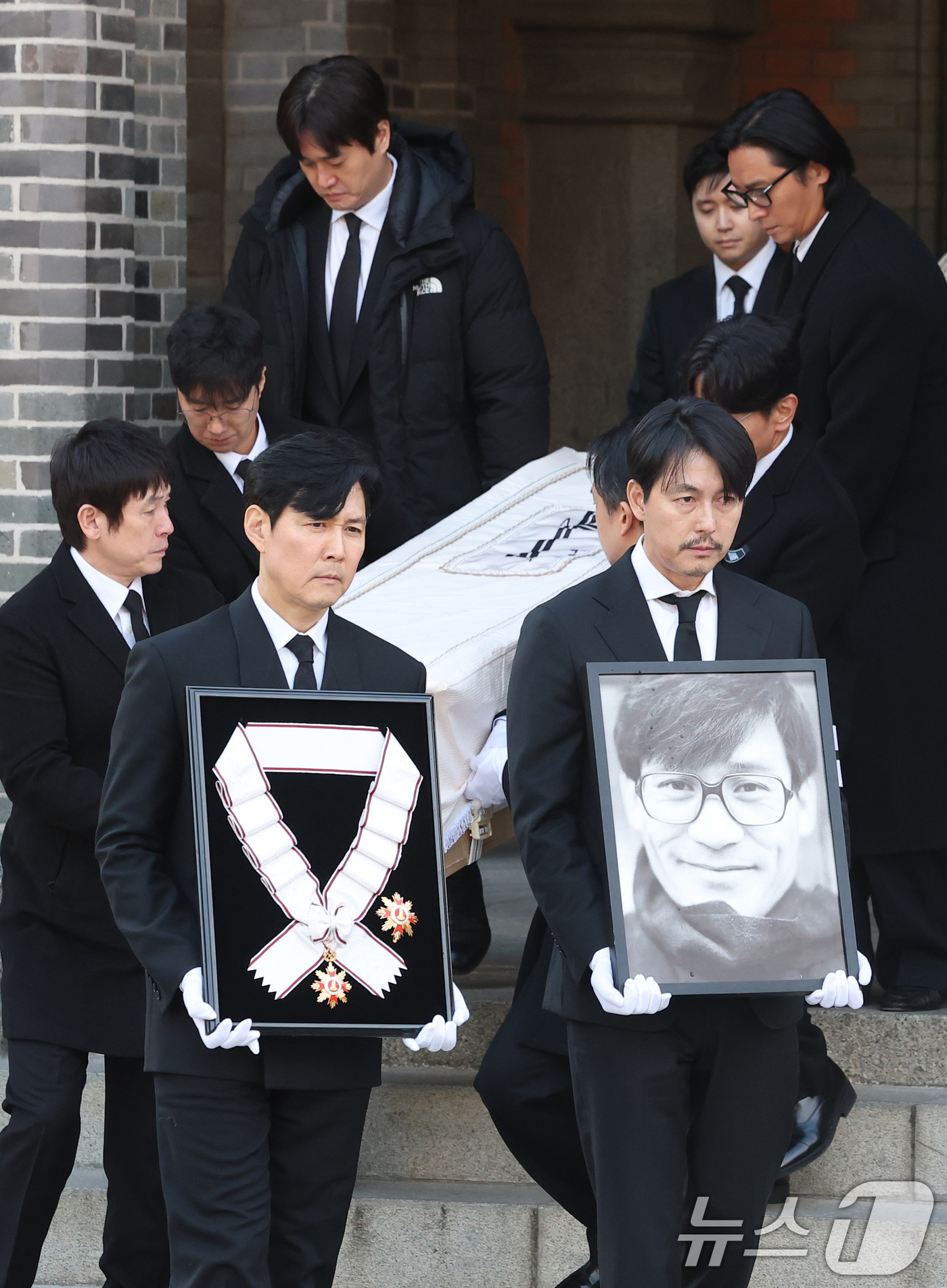 (서울=뉴스1) 권현진 기자 = 배우 이정재와 정우성이 9일 오전 서울 중구 명동성당에서 고 안성기의 장례 미사를 마친 뒤 영결식장으로 향하고 있다. 정우성은 고인의 영정을, 이정 …