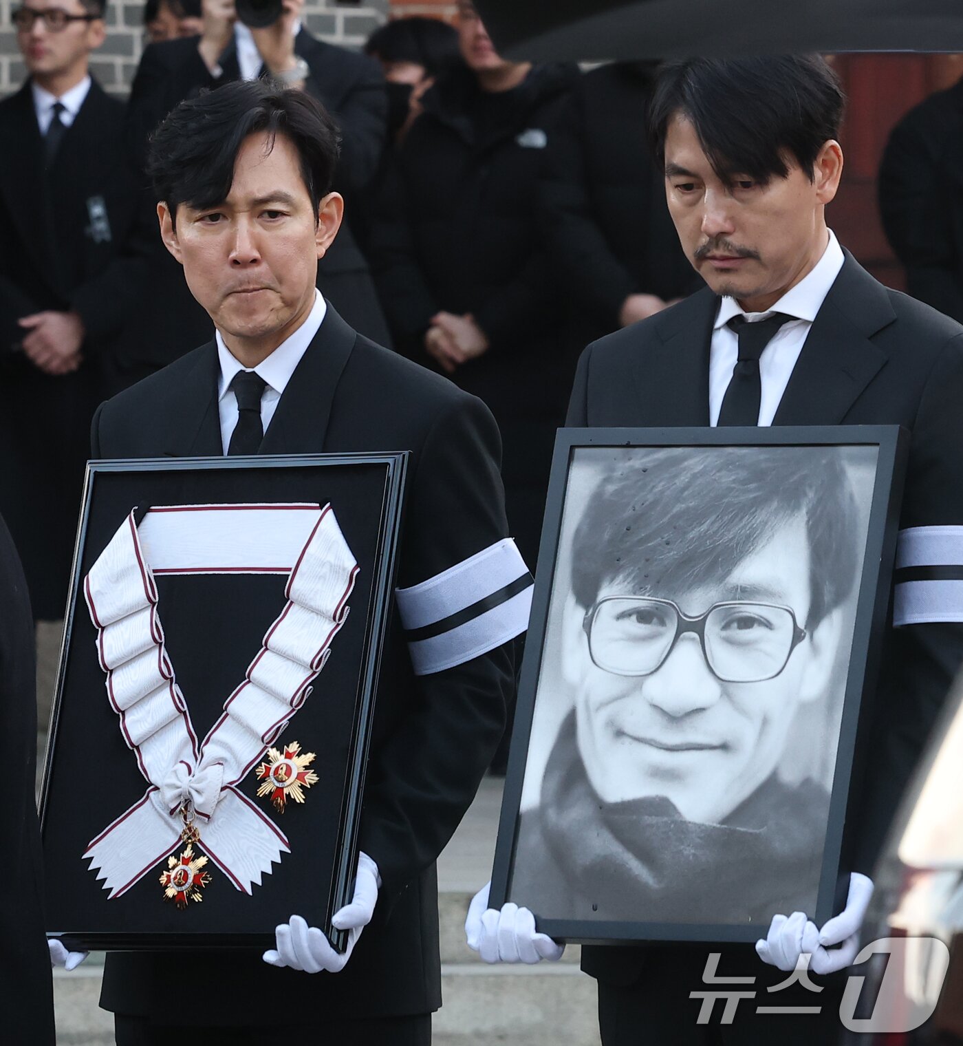 본문 이미지 - 배우 이정재와 정우성(오른쪽)이 9일 오전 서울 중구 명동성당에서 고 안성기의 발인식이 거행되고 있다. 정우성은 고인의 영정을, 이정재는 금관문화훈장을 들고 있다. 2026.1.9/뉴스1 ⓒ News1 권현진 기자