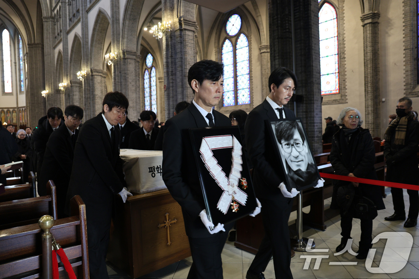 (서울=뉴스1) 임세영 기자 = 배우 이정재와 정우성이 9일 오전 서울 중구 명동성당에서 고 안성기의 장례 미사를 마친 뒤 영결식장으로 향하고 있다. 정우성은 고인의 영정을, 이정 …