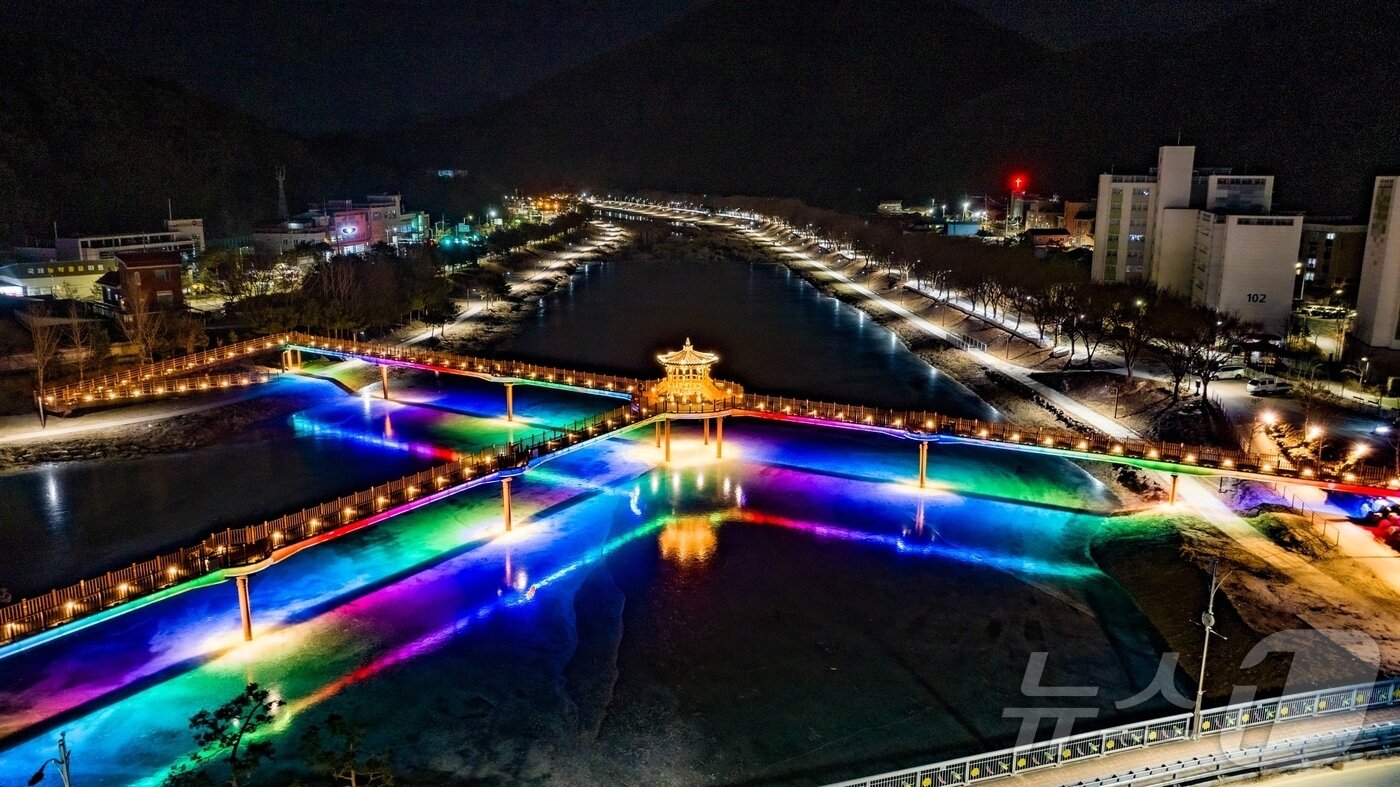 본문 이미지 - 충북 괴산군 괴산읍 성황천과 동진천을 연결하는 에코브릿지의 경관조명이 얼음에 반영돼 겨울밤 수변의 이색적인 풍경을 연출하고 있다.(괴산군 제공).2026.1.9 .