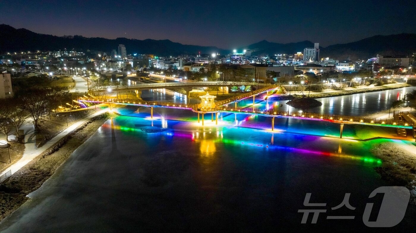 본문 이미지 - 충북 괴산군 괴산읍 성황천과 동진천을 연결하는 에코브릿지의 경관조명이 얼음에 반영돼 겨울밤 수변의 이색적인 풍경을 연출하고 있다.(괴산군 제공).2026.1.9 .