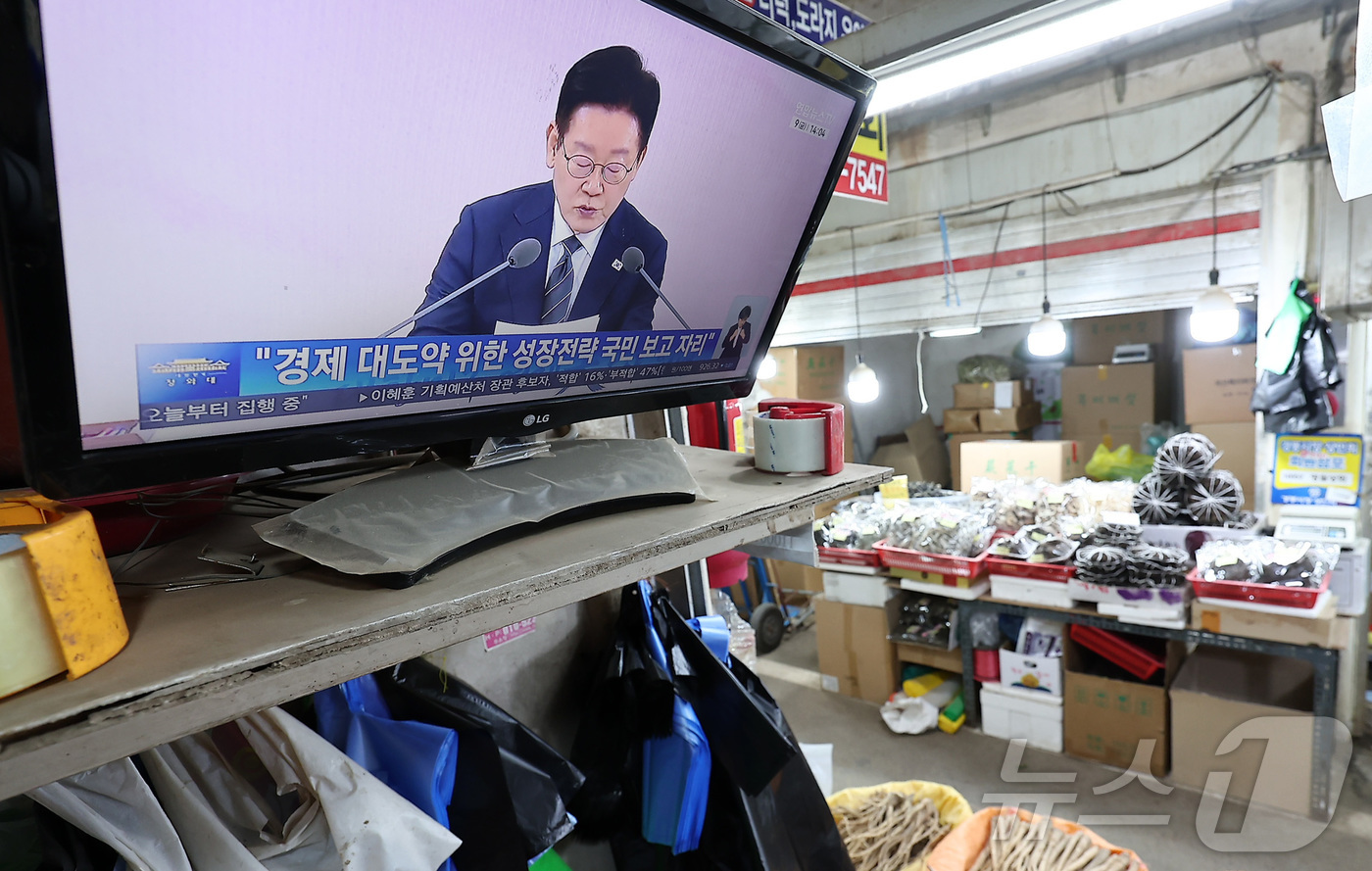 (서울=뉴스1) 김성진 기자 = 9일 서울 동대문구 경동시장에서 한 상인이 이재명 대통령의 경제성장전략 국민보고회를 시청하고 있다.이재명 정부는 이날 열린 '2026년 경제성장전략 …