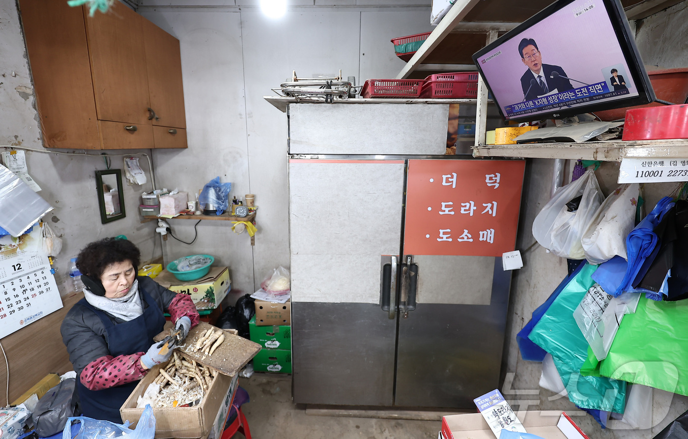 (서울=뉴스1) 김성진 기자 = 9일 서울 동대문구 경동시장에서 한 상인이 이재명 대통령의 경제성장전략 국민보고회를 시청하고 있다.이재명 정부는 이날 열린 '2026년 경제성장전략 …