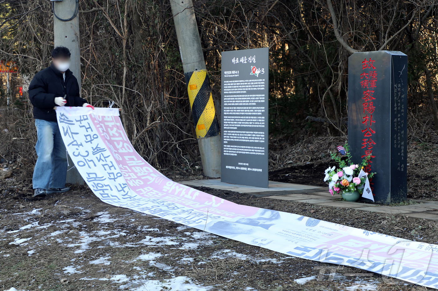 (제주=뉴스1) 오미란 기자 = 제주시 연동 주민센터 공무원이 9일 오후 제주시 연동 4·3 역사 왜곡 대응 안내판 \'바로 세운 진실\' 앞에 설치된 4·3 역사 왜곡 현수막을 …