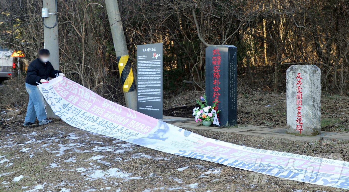 본문 이미지 - 제주시 연동 주민센터 공무원이 9일 오후 제주시 연동 4·3 역사 왜곡 대응 안내판 '바로 세운 진실' 앞에 설치된 4·3 역사 왜곡 현수막을 강제 철거하고 있다. ⓒ News1 오미란 기자