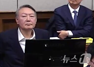 본문 이미지 - 윤석열 전 대통령이 9일 서울 서초구 서울중앙지방법원에서 열린 내란 우두머리 혐의 1심 결심 공판에 출석해 자리에 앉아 있다. (서울중앙지방법원 제공 영상 캡쳐. 재판매 및 DB 금지) 2026.1.9/뉴스1 ⓒ News1 임세영 기자